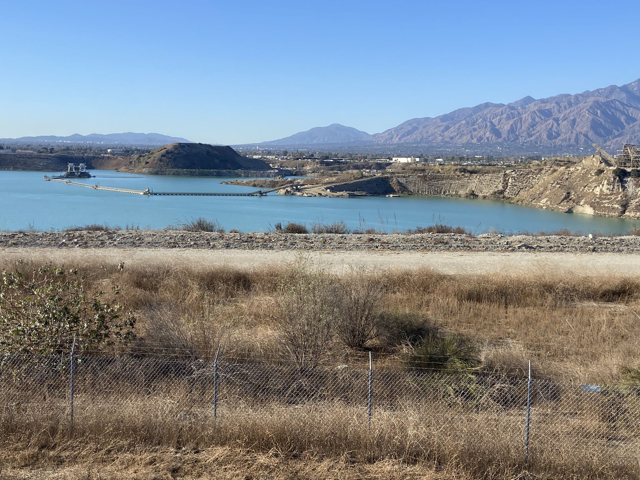 A large lake with mountains in the background under a clear sky. - Rio Hondo Greenway Loop