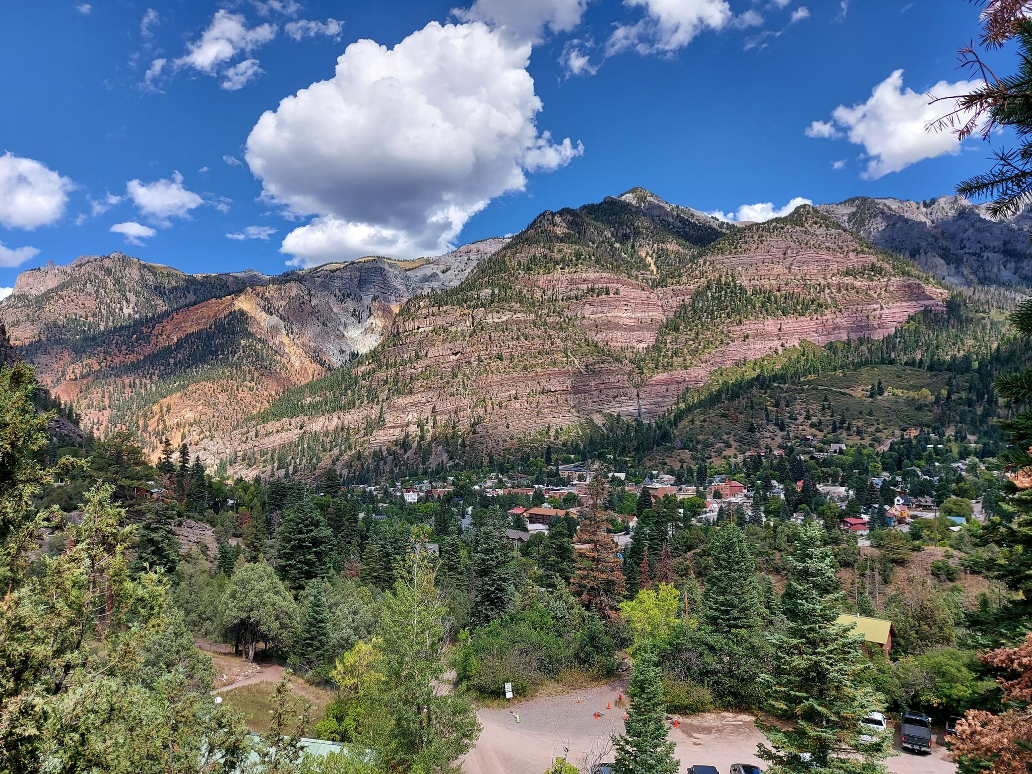 Mountainous landscape with a town nestled in the valley, under a sunny sky. - Ouray Perimeter Trail
