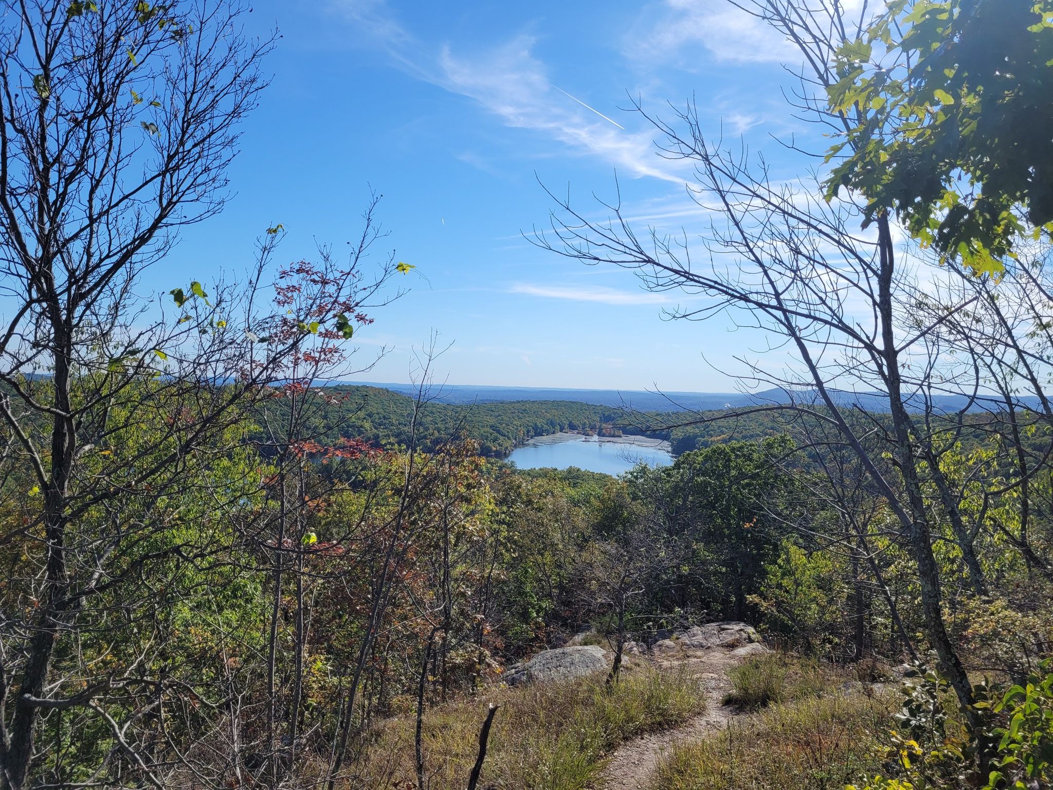 Scenic overlook of a lake nestled in green hills under a blue sky. - Ramapo Lake Spur, Castle, Wanaque Ridge, and LeGrande Hill Trail