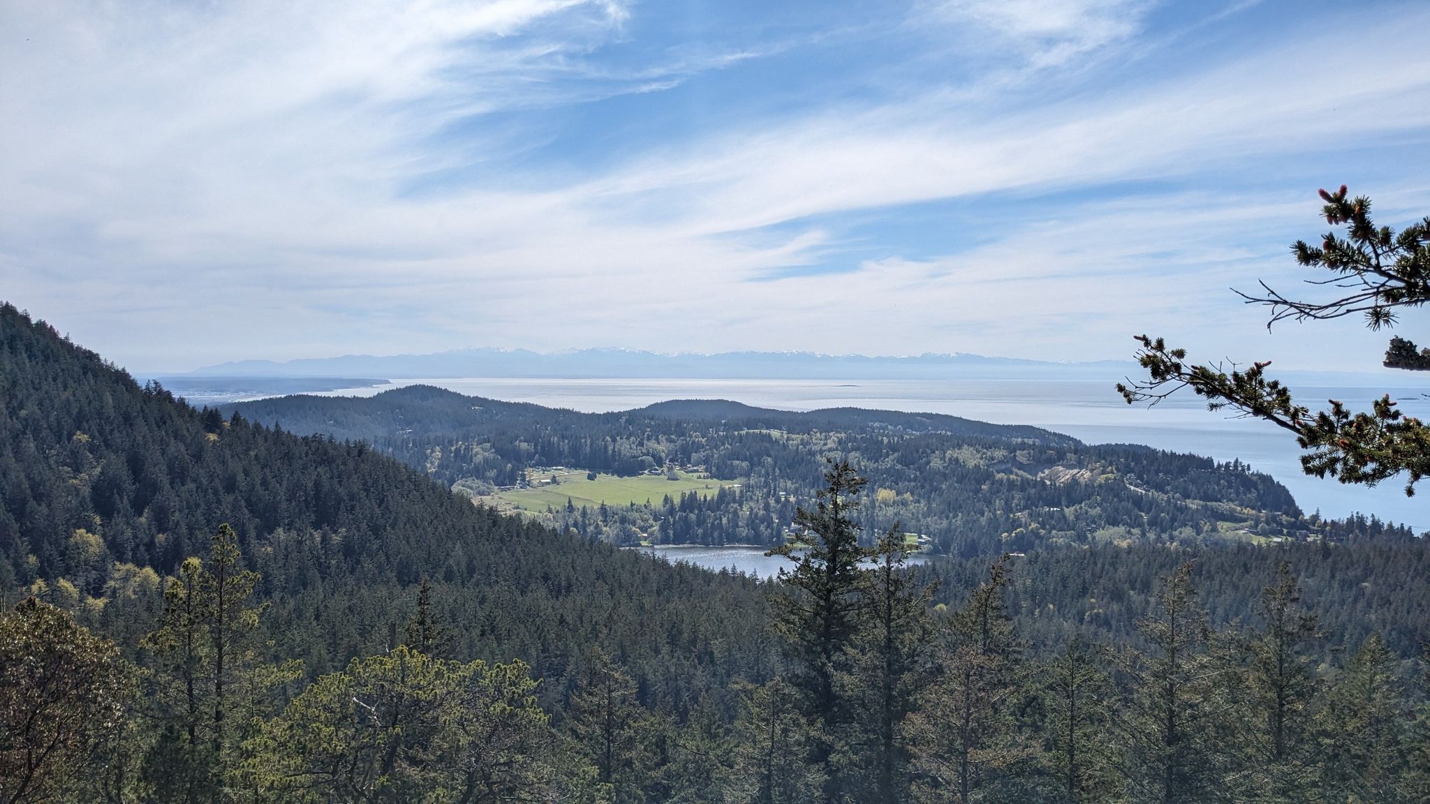 Panoramic view of forested hills, a lake, and distant water under a cloudy sky. - Sugar Loaf & Mount Erie loop
