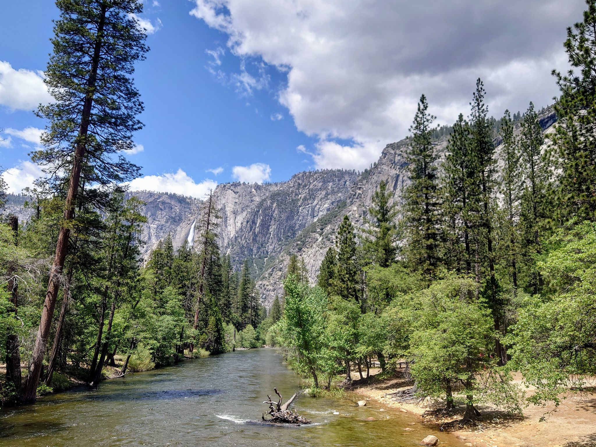 River flows through a forested valley with mountains under a partly cloudy sky. - Lower and Upper Mirror Lakes loop from Valley Shuttle Stop #15