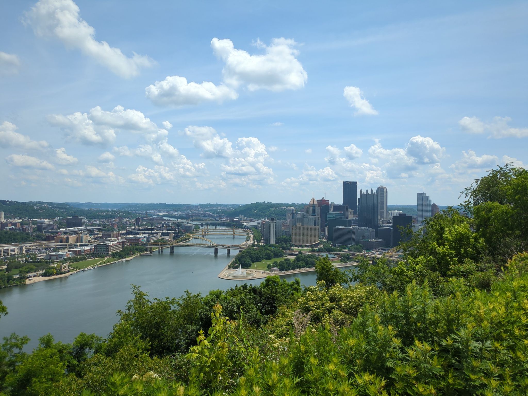 Sunny city skyline with river, bridges, and green hills under blue sky. - Three Rivers Heritage Trail and Sewickley Loop
