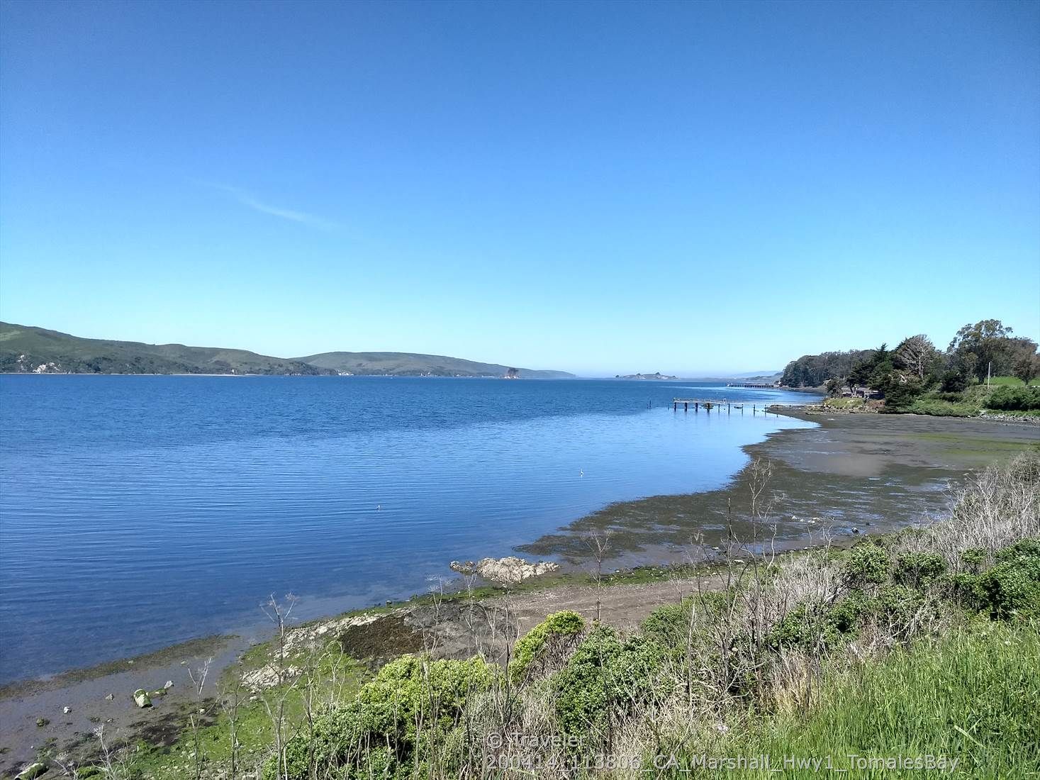 A calm bay with distant hills under a clear blue sky. - Nick's Cove and Boat Launch – Tomales loop from Tomales