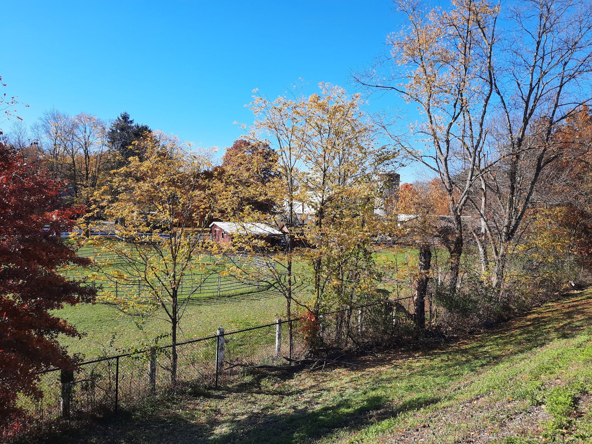 A red barn and silo in a sunny autumn landscape with colorful trees. - Osborne Hill loop from Town of Fishkill