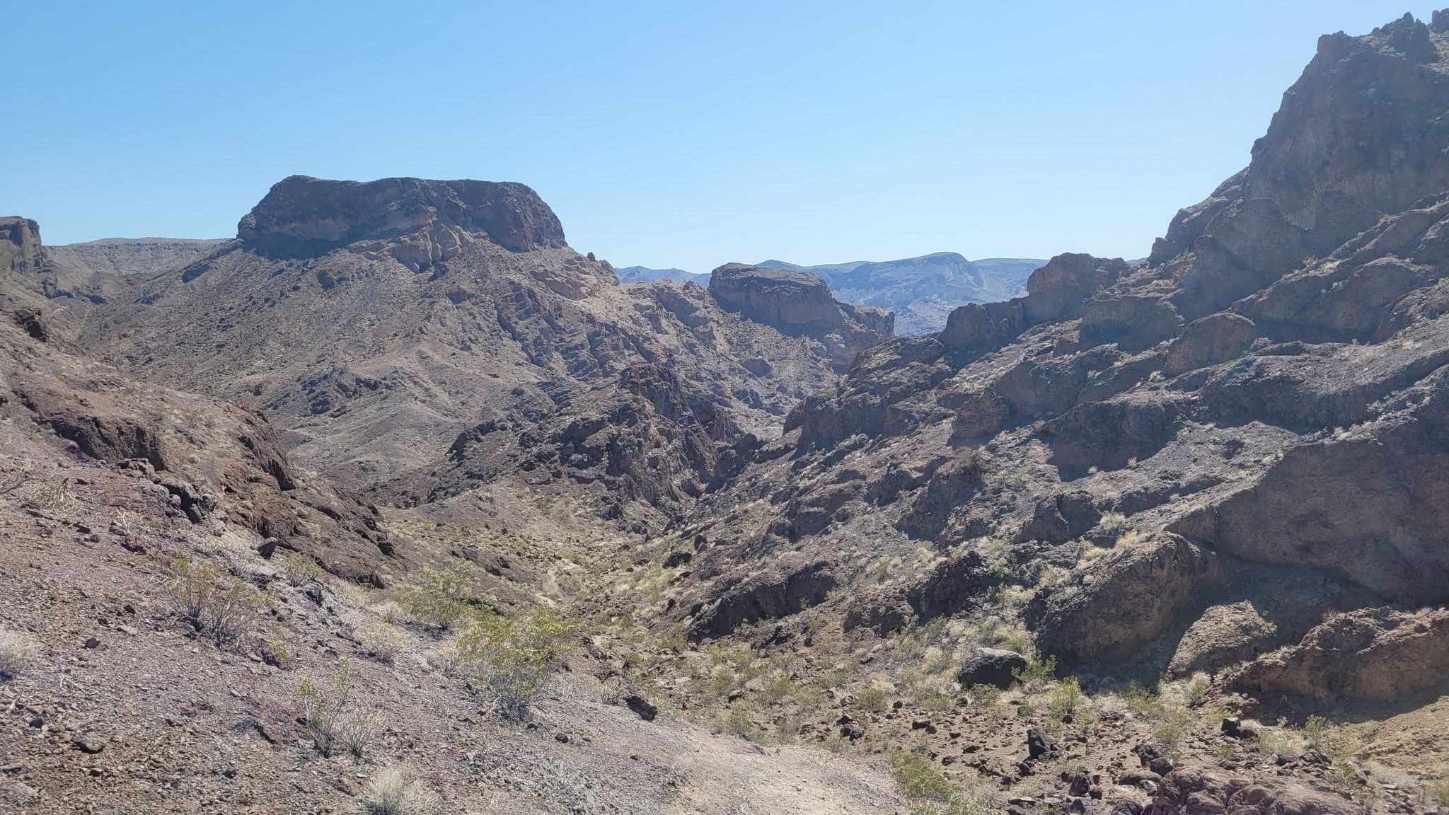 Vast desert canyon landscape with rugged mountains and a clear blue sky. - Arizona Hot Spring Trail