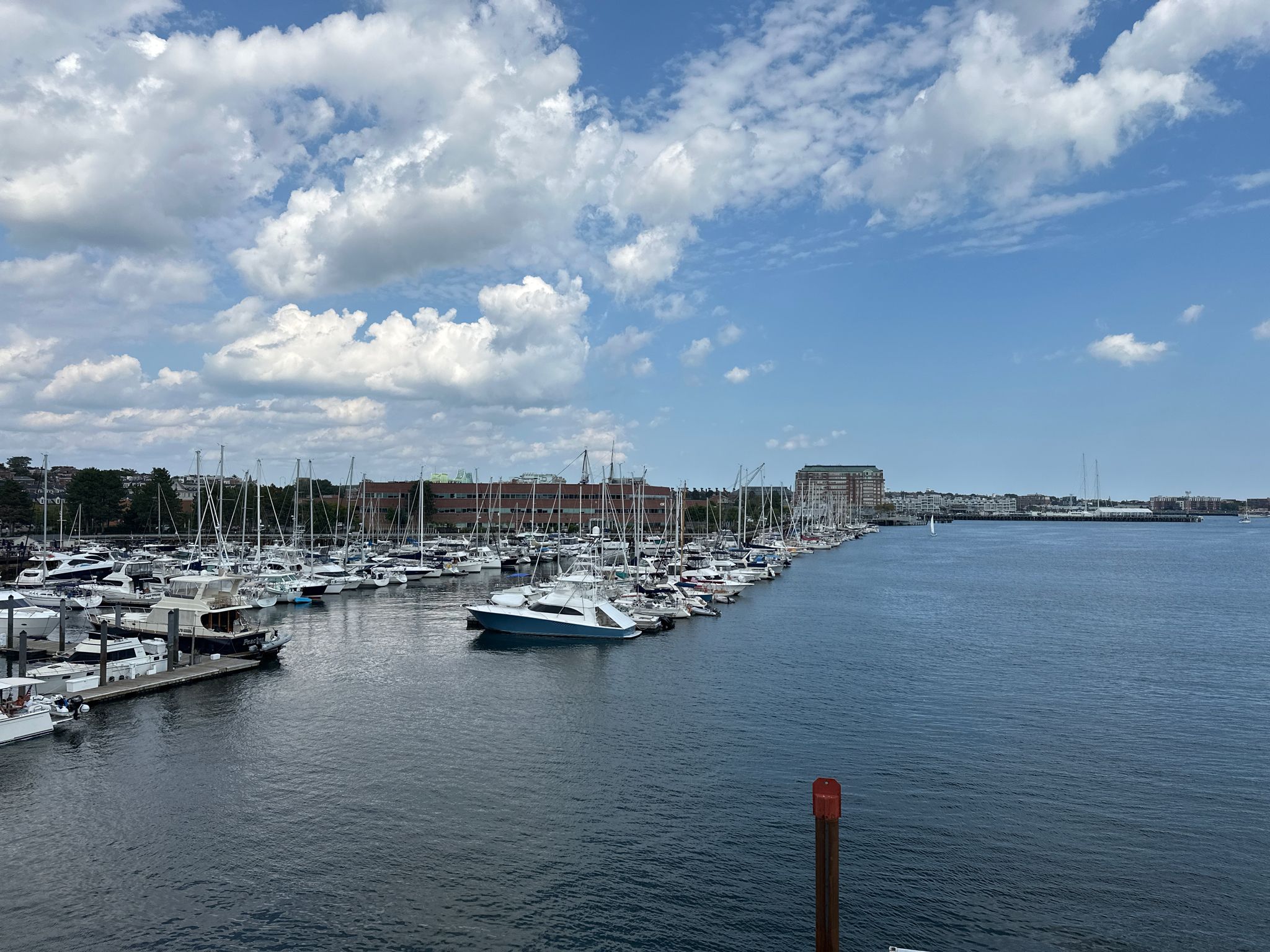 A wide marina filled with boats under a partly cloudy blue sky. - Freedom Trail