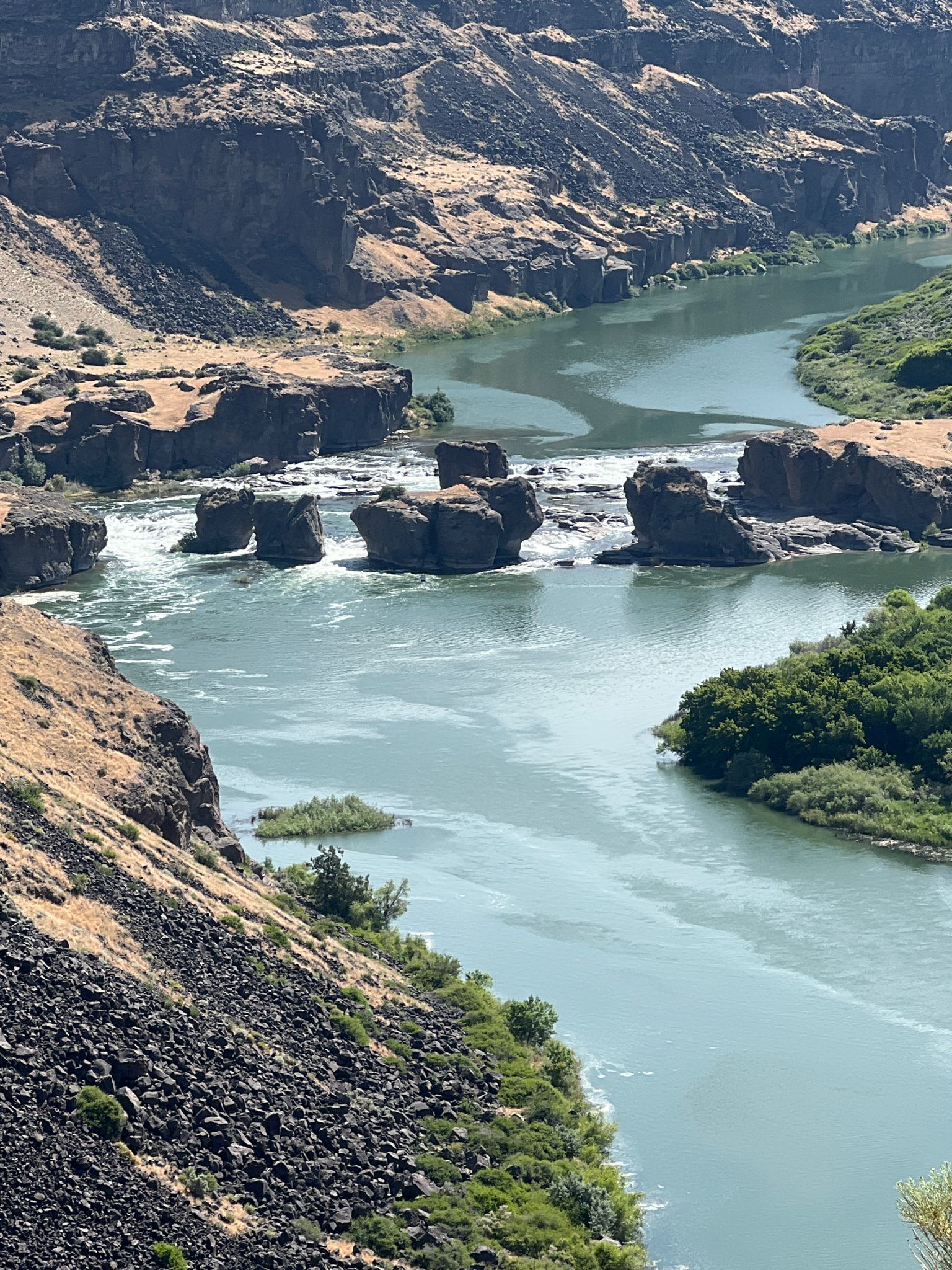 River with rapids and large rock formations in a deep canyon. - Canyon Rim Trail