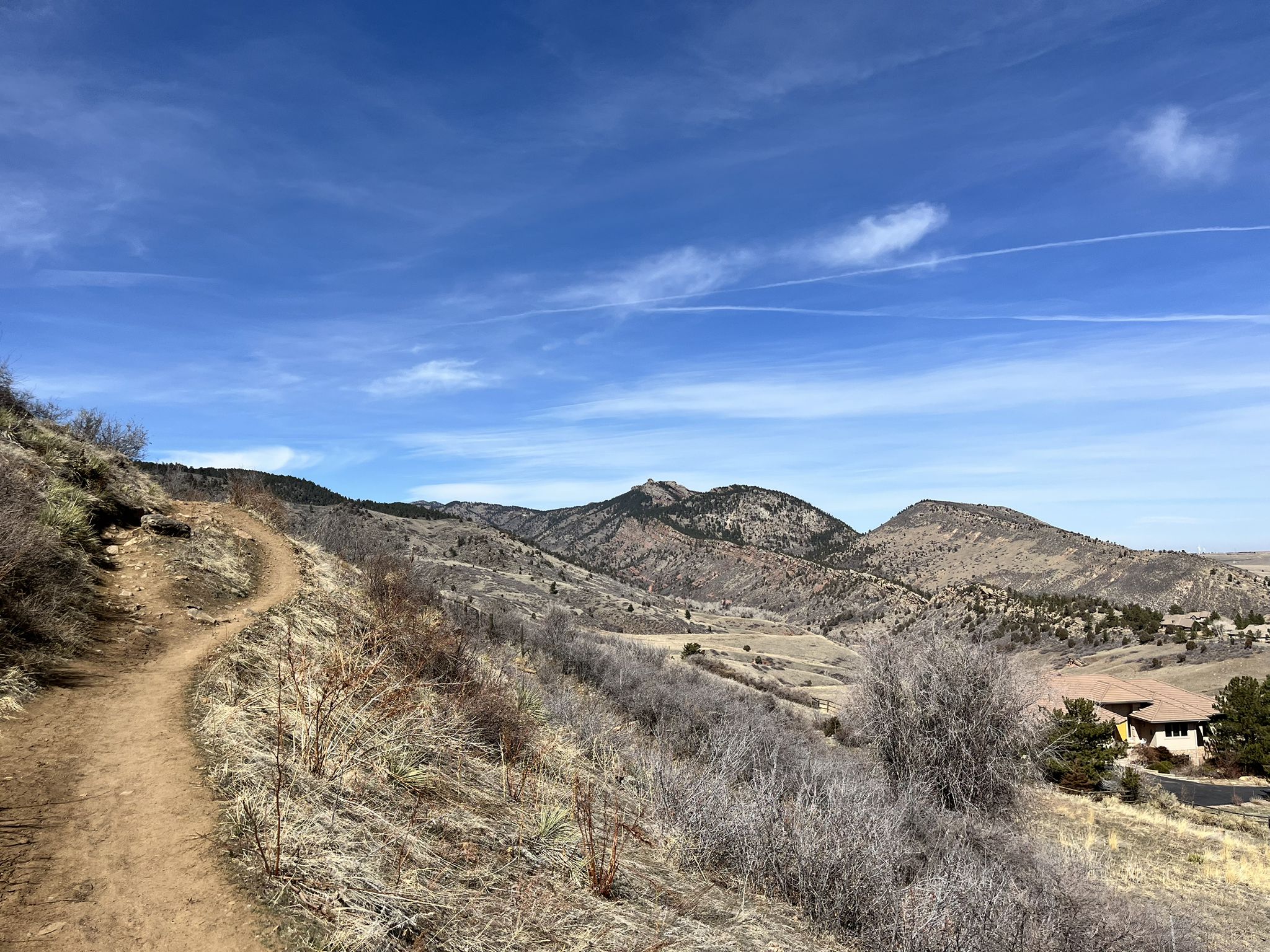 Dirt trail winding up dry hills under a bright blue sky. - White Ranch Open Space Outside Loop