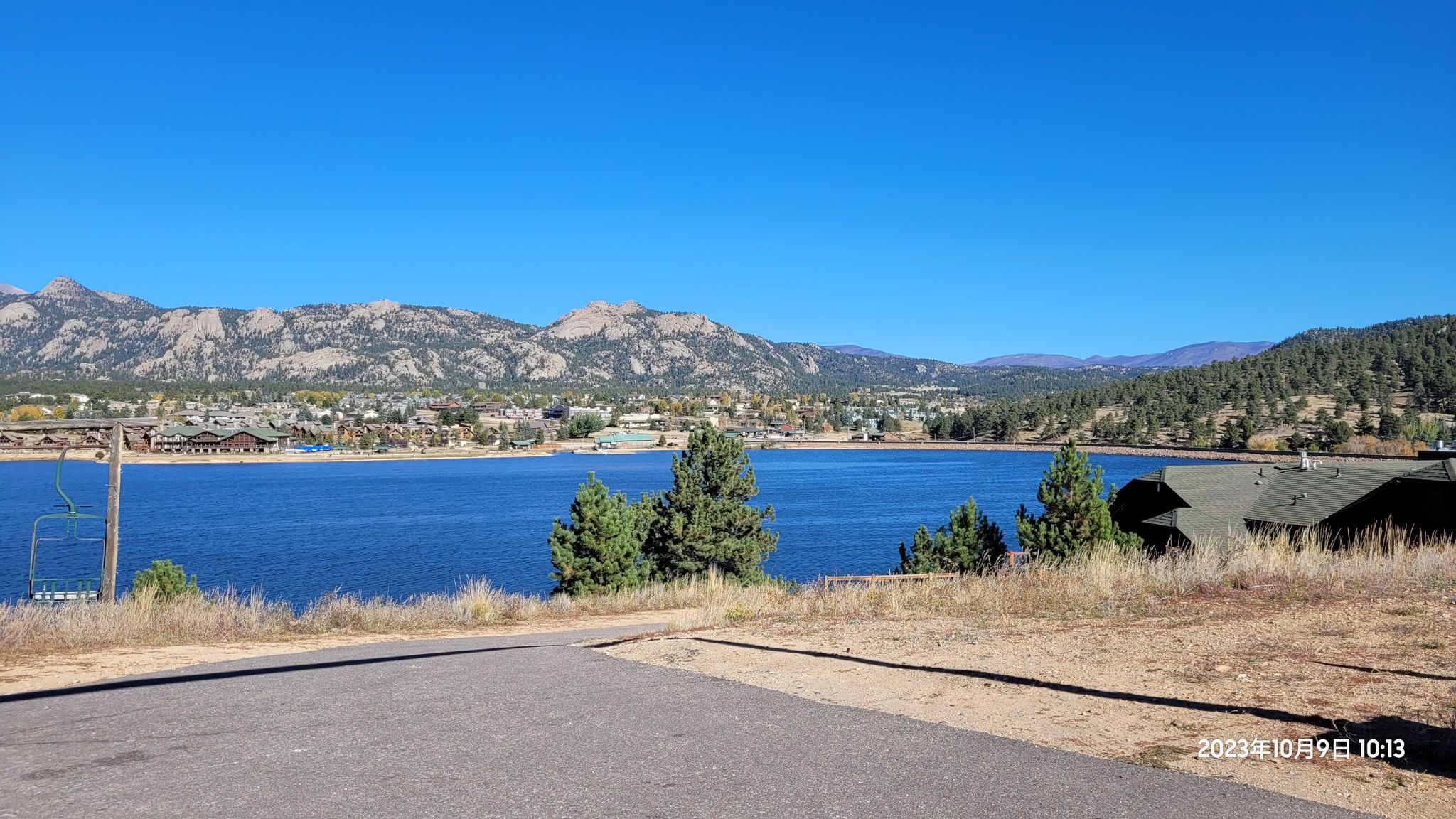 Expansive lake view with distant town, mountains, and clear blue sky. - Limber Pine Trail loop from Estes Park