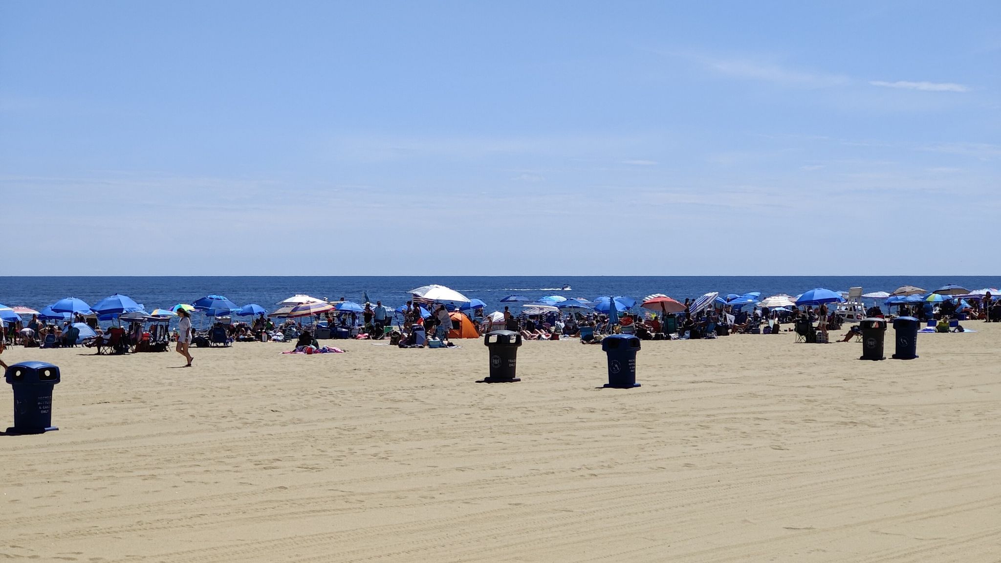 Crowded beach with many colorful umbrellas and people under a clear sky. - Hiking loop from Neptune City