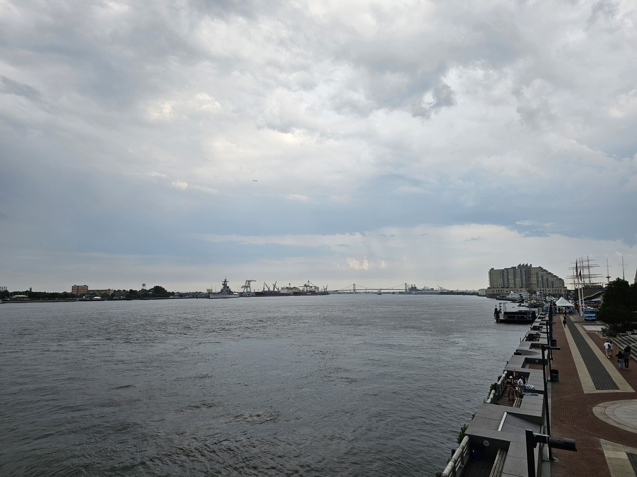Wide river view with a waterfront promenade and distant city under cloudy skies. - Independence National Historical Park loop
