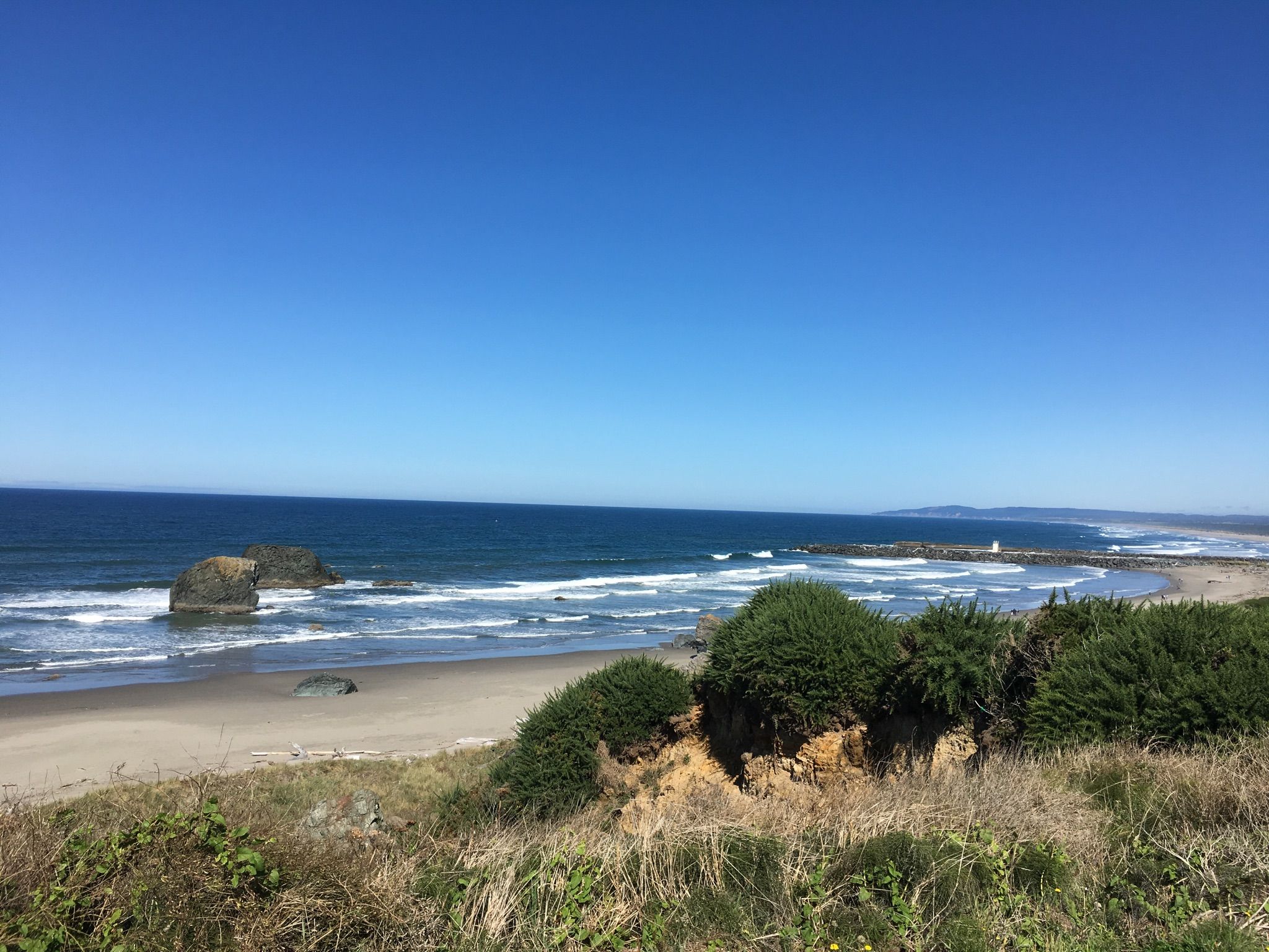 Sunny coastal view with ocean waves, sandy beach, and sea stacks. - Coquille Point – South Slough Inlet loop from Wash Rock