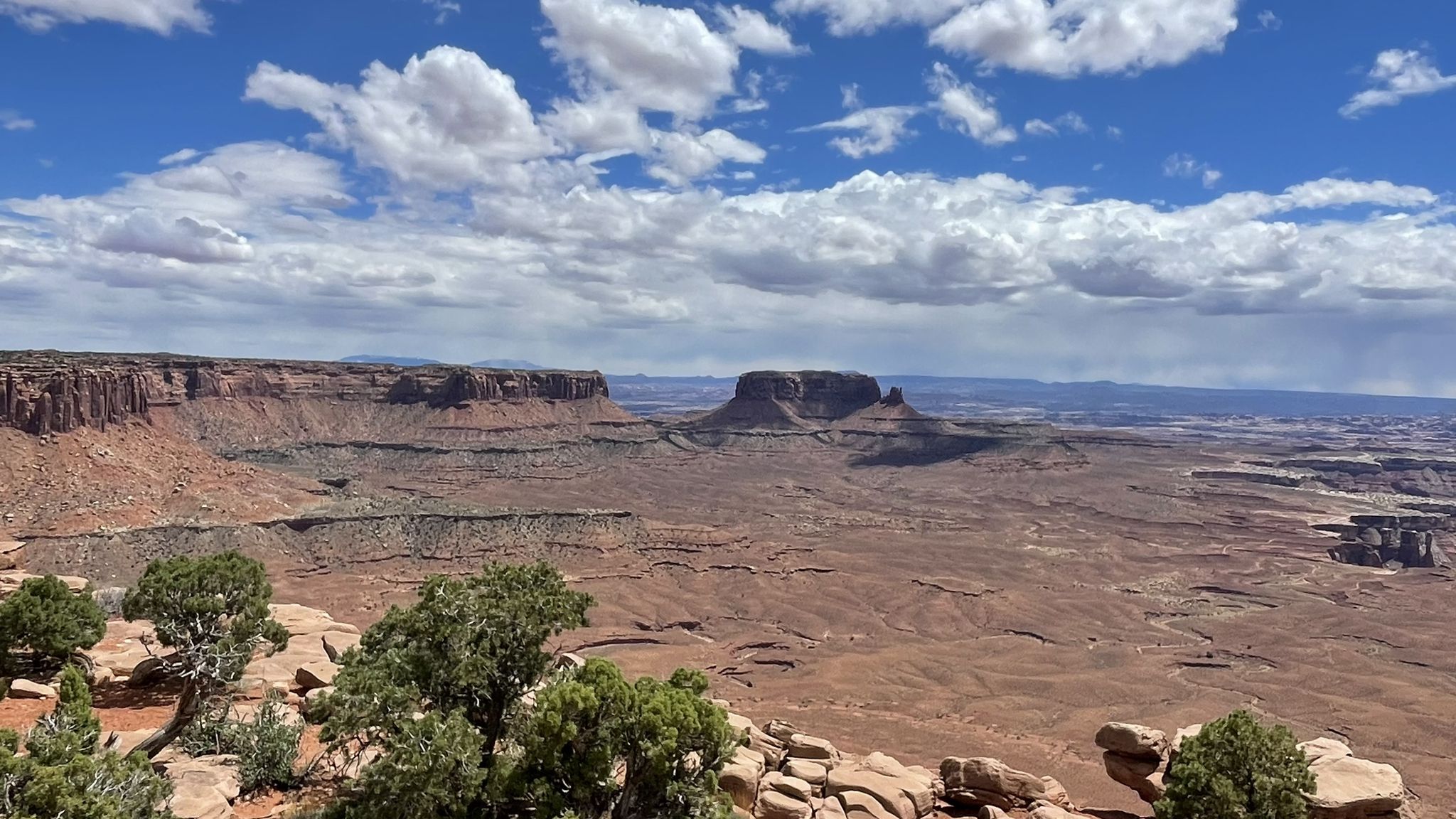 Expansive desert landscape with distant mesas under a partly cloudy sky. - Murphy Point Trail