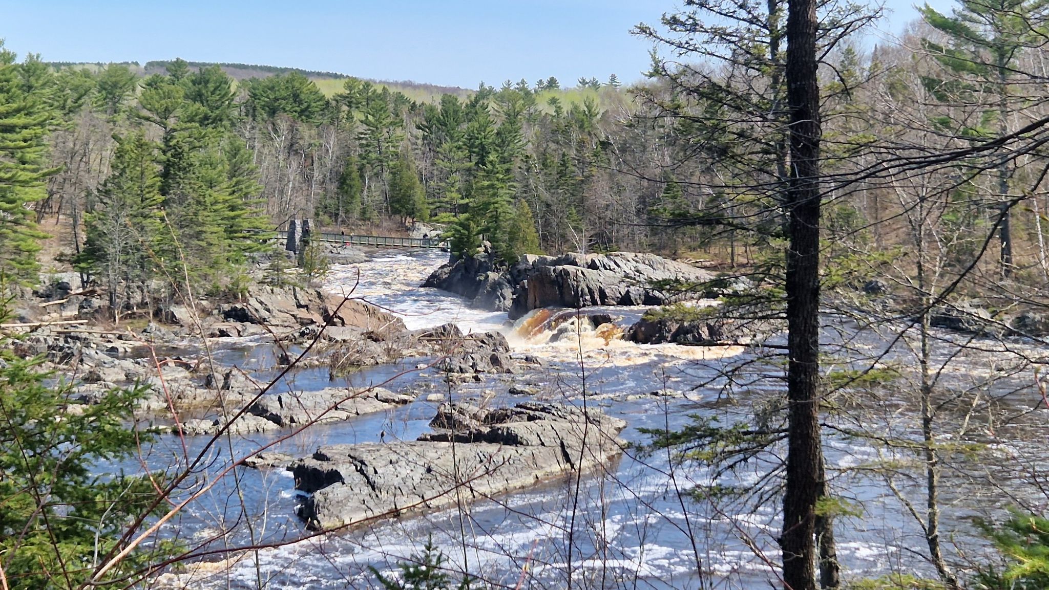 Rocky river with foamy rapids flowing through a forest under a bright blue sky. - Carlton Trail and Willard Munger State Trail Loop