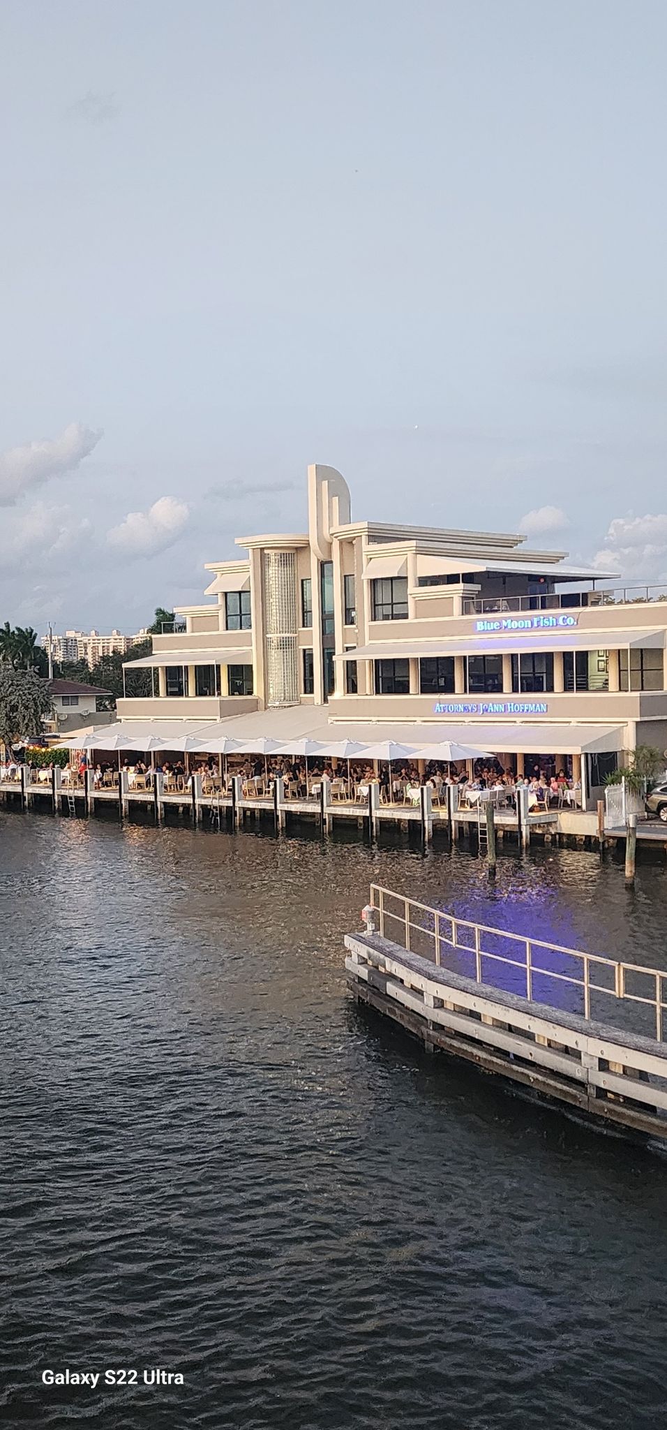 Waterfront restaurant with people dining, next to a boat dock under an overcast sky. - Lauderdale-by-the-Sea Beach – Hugh Taylor Birch State Park loop from Lauderdale-by-the-Sea