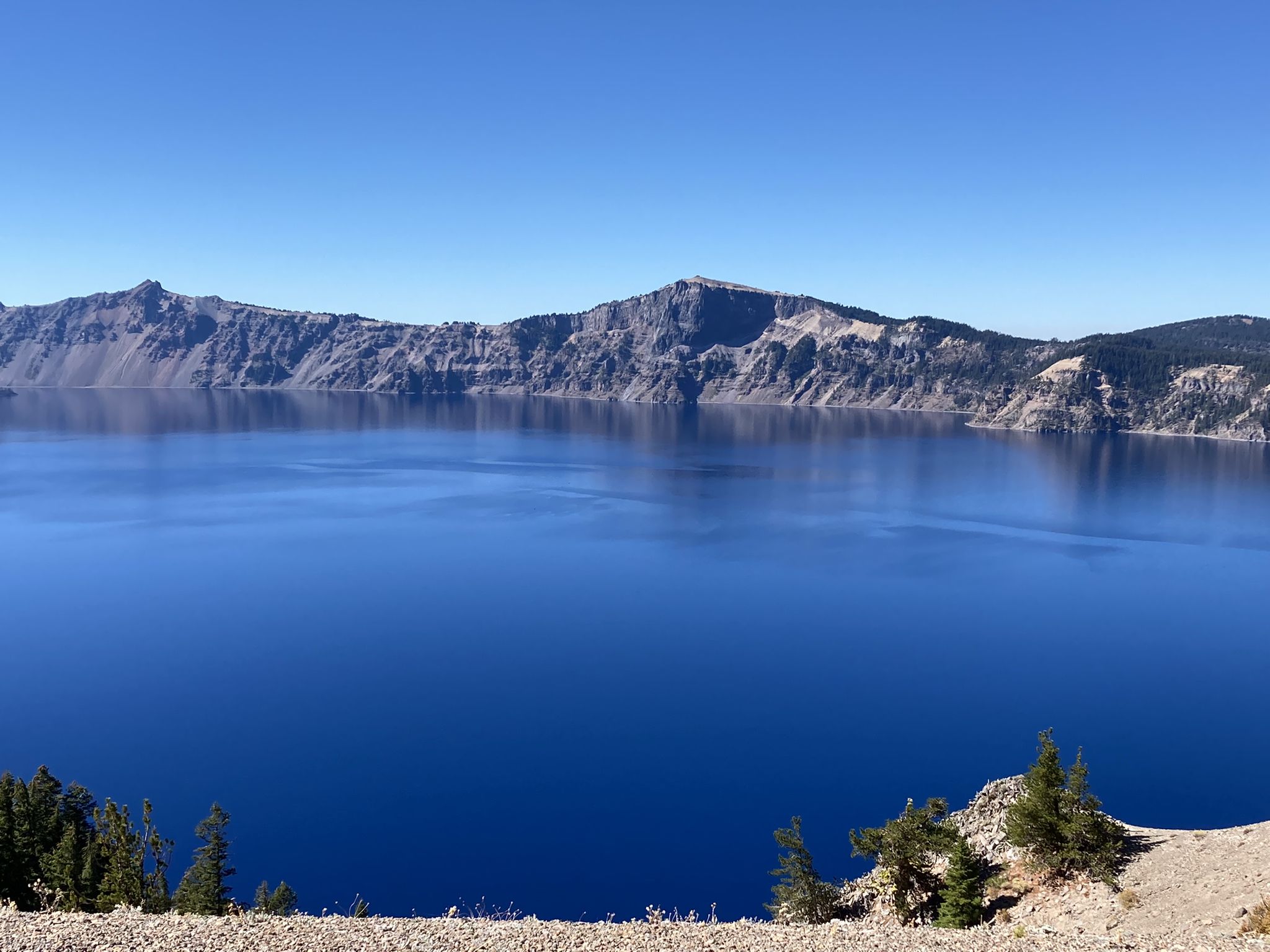 Deep blue lake surrounded by steep, rocky cliffs under a clear sky. - Skell Head to Cloudcap Viewpoint