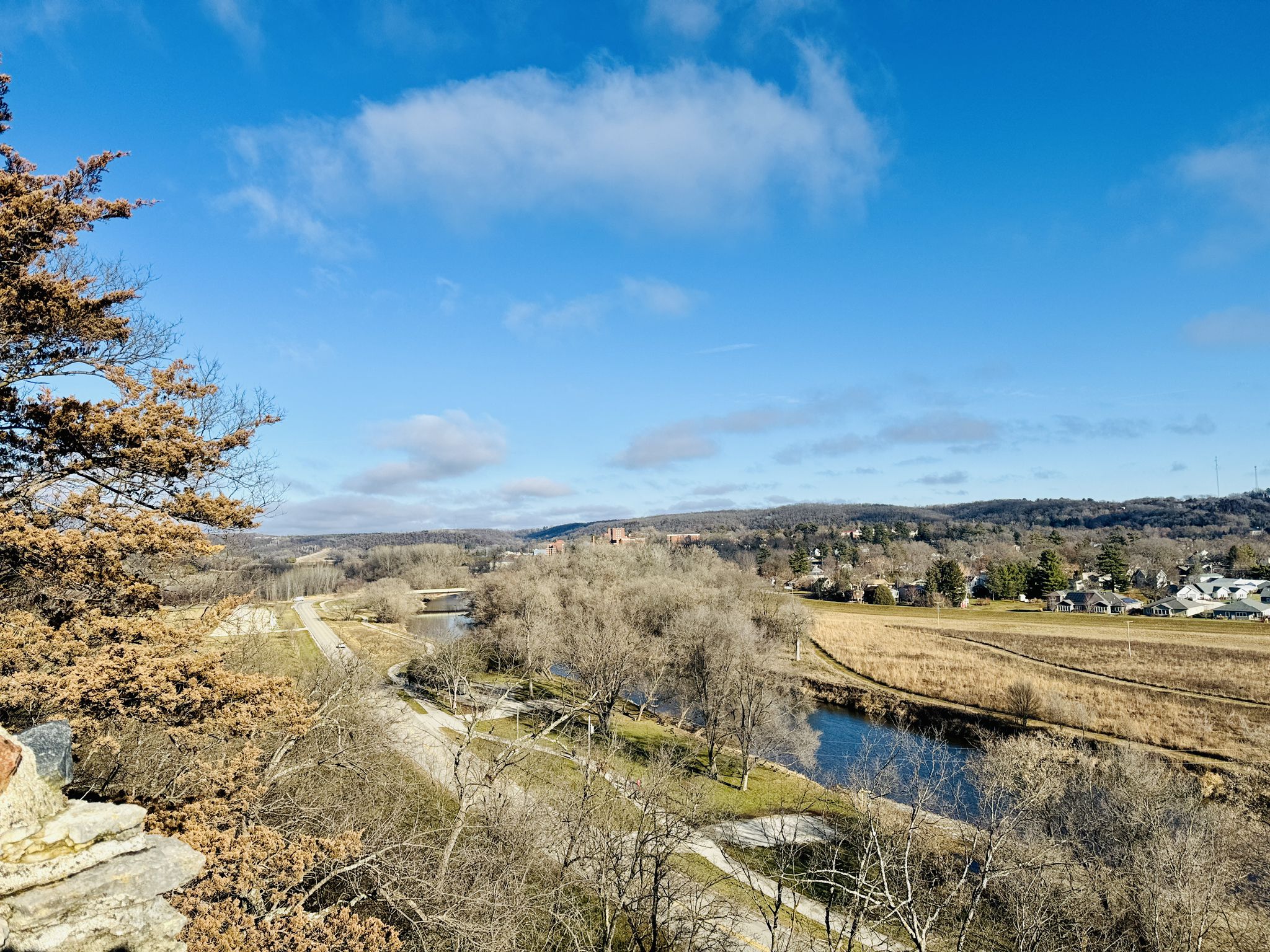 Bright aerial view of a winding river through a valley with bare trees. - Pulpit Rock Overlook via Yggdrasil Loop