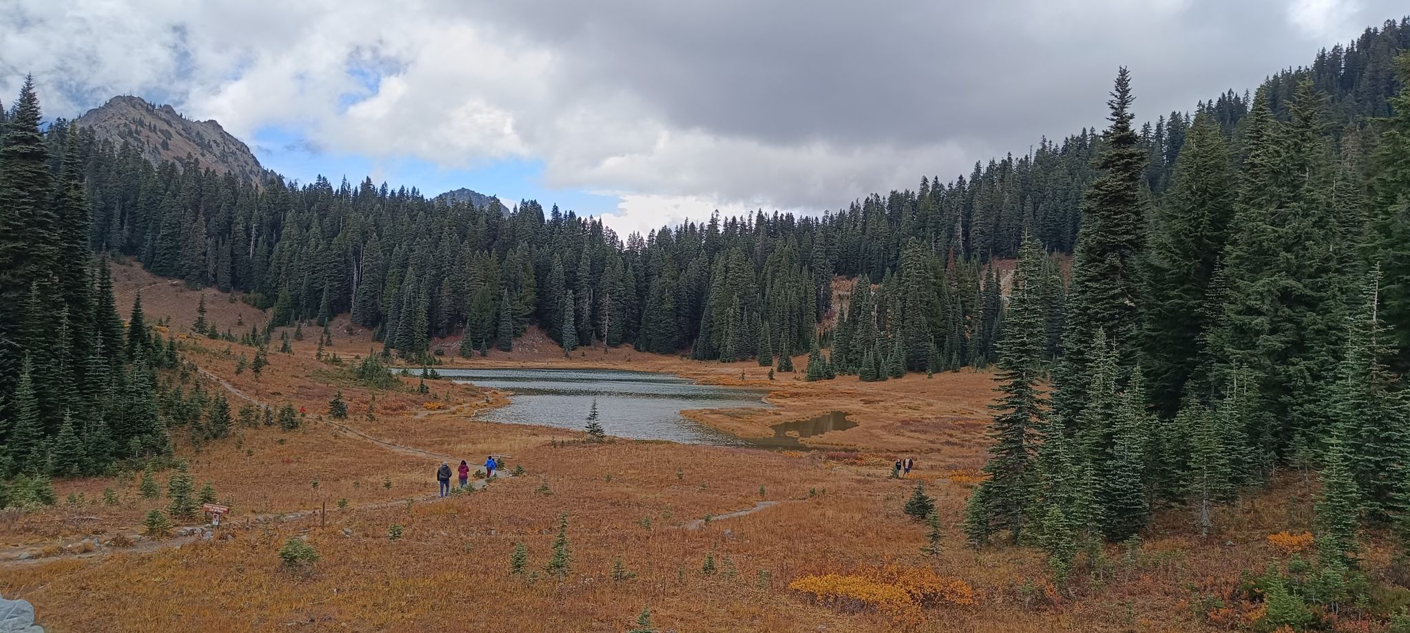 Panoramic view of a lake in an autumn valley with hikers. - Tipsoo Lake – Chinook Pass loop from Crystal Lake Trailhead