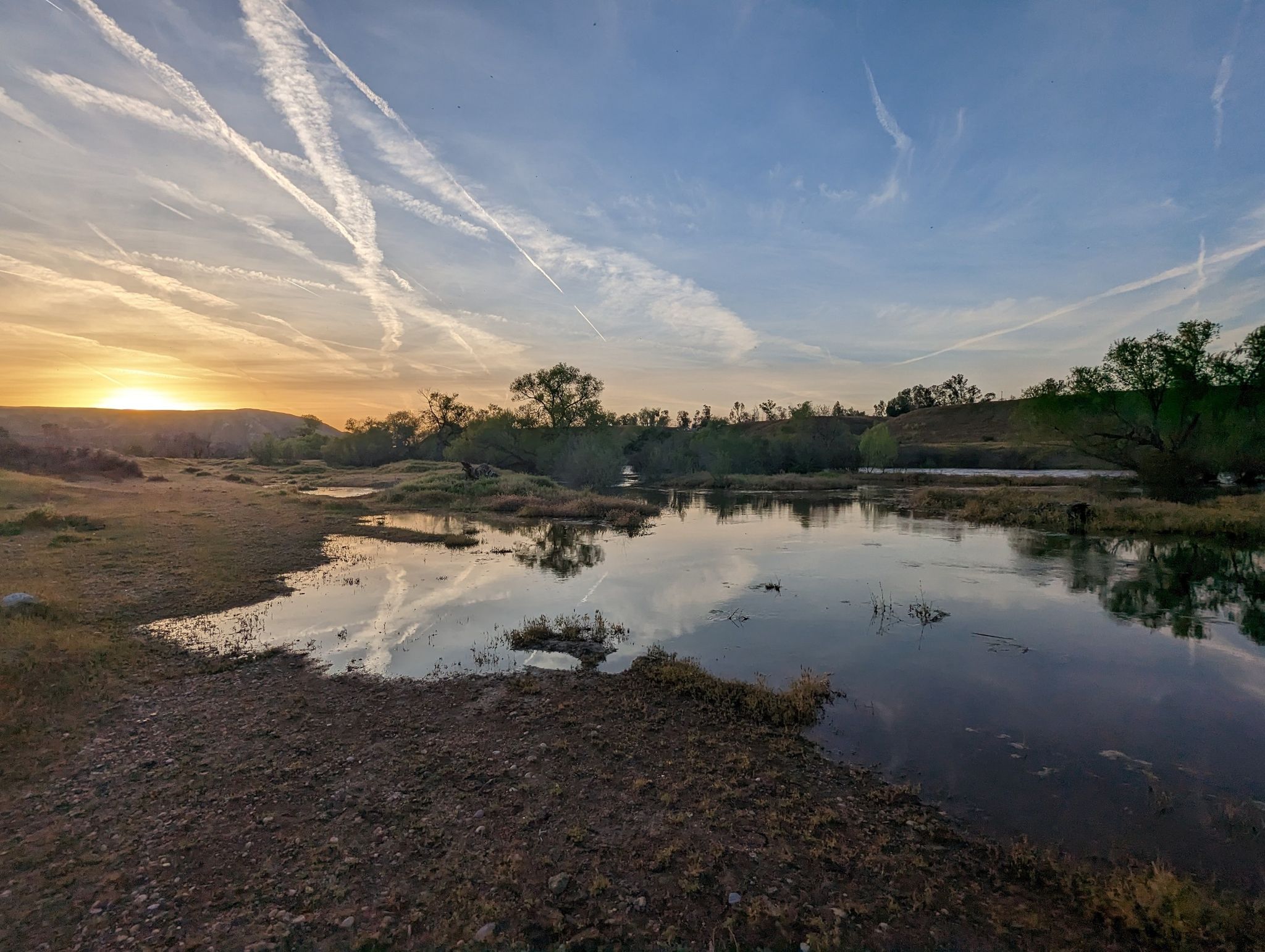 Sunset over a calm lake with reflections, surrounded by trees and dramatic cloud trails. - Mushroom Meadow – Luna Lake loop from Lake Ming County Park