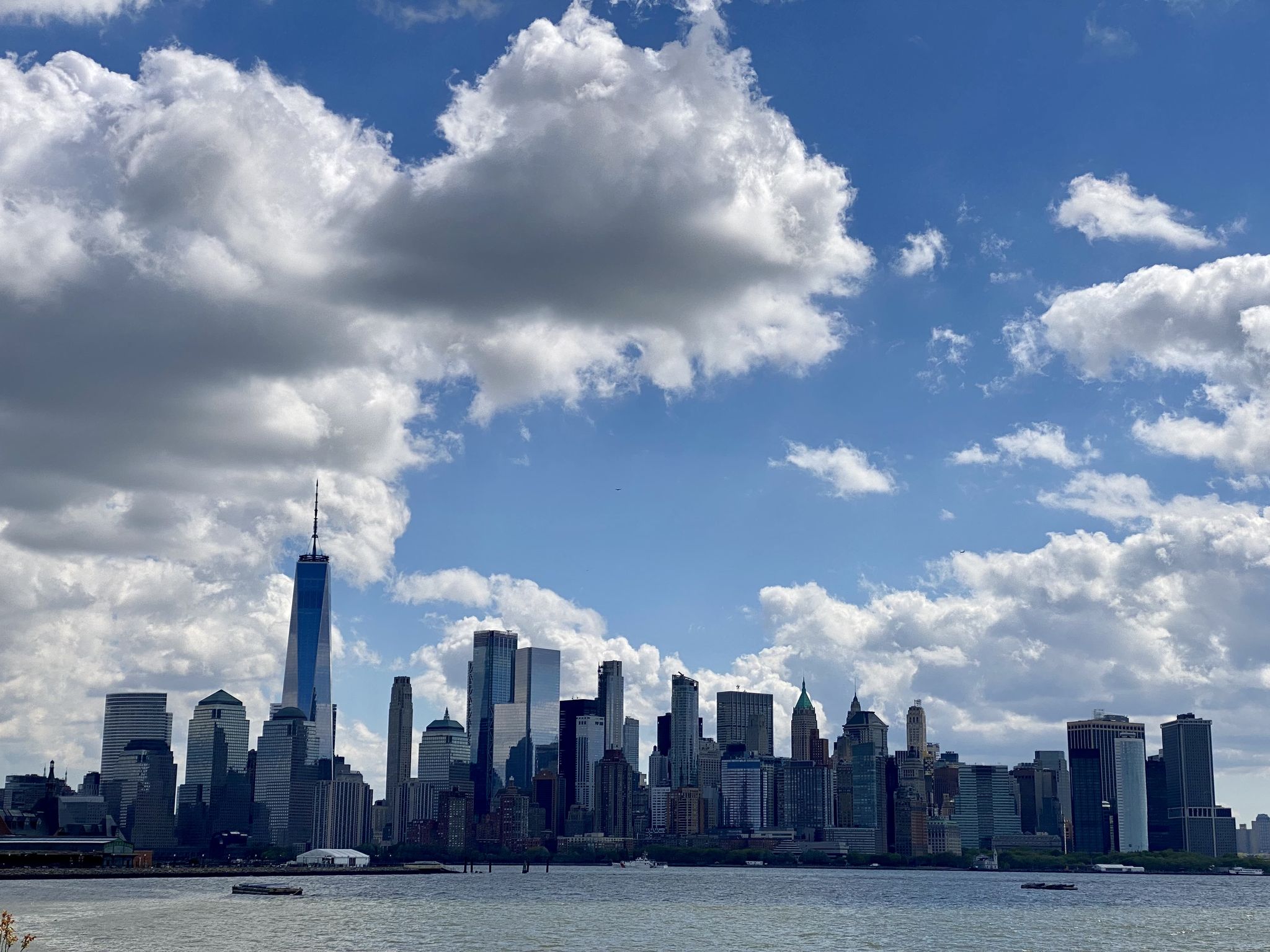 City skyline across water under a bright blue sky with fluffy white clouds. - Goethals Bridge – Warinanco Park loop from Cranford