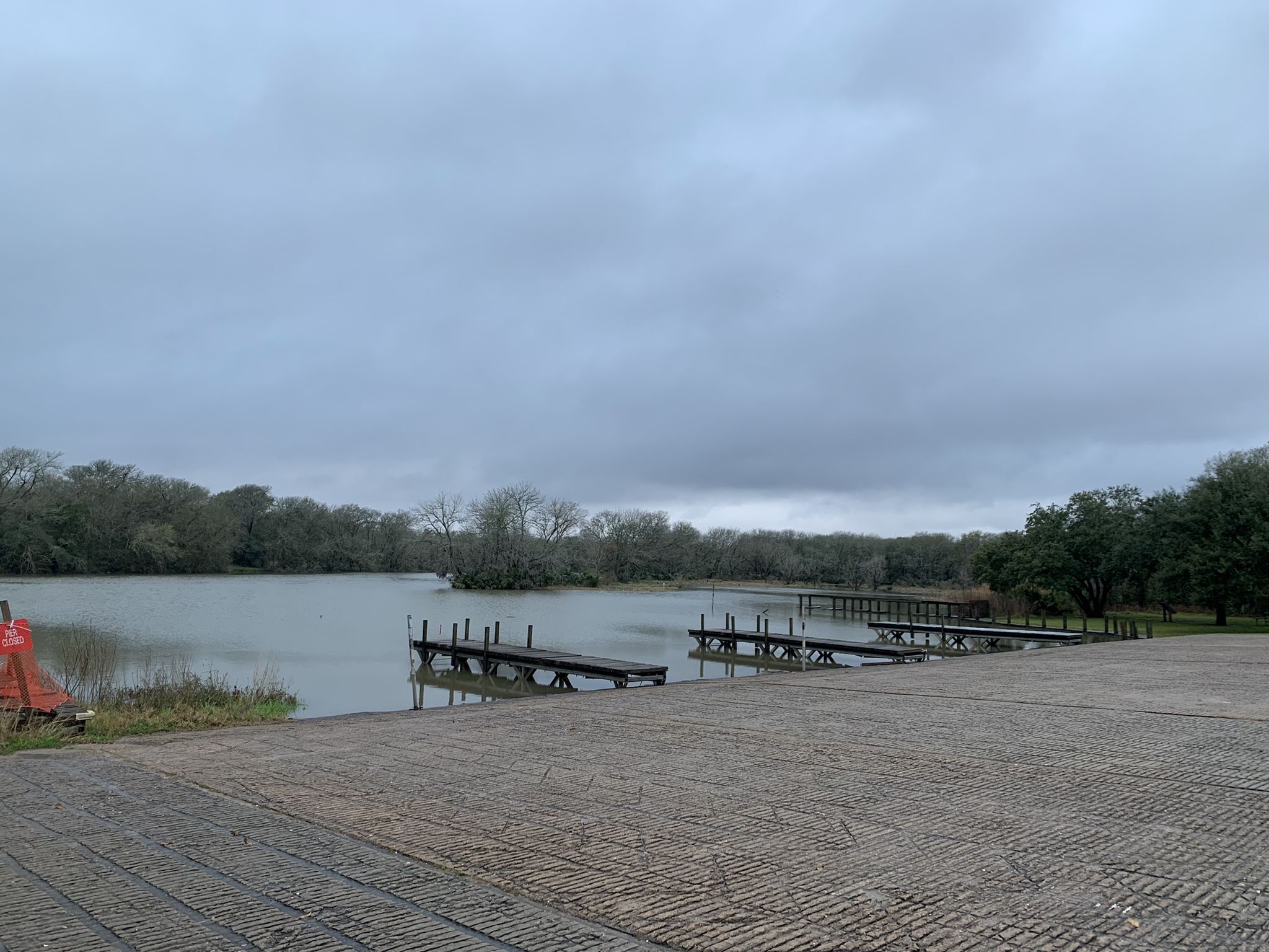 Overcast day at a boat ramp with empty docks on a calm lake. - Challenger Seven Park Loop
