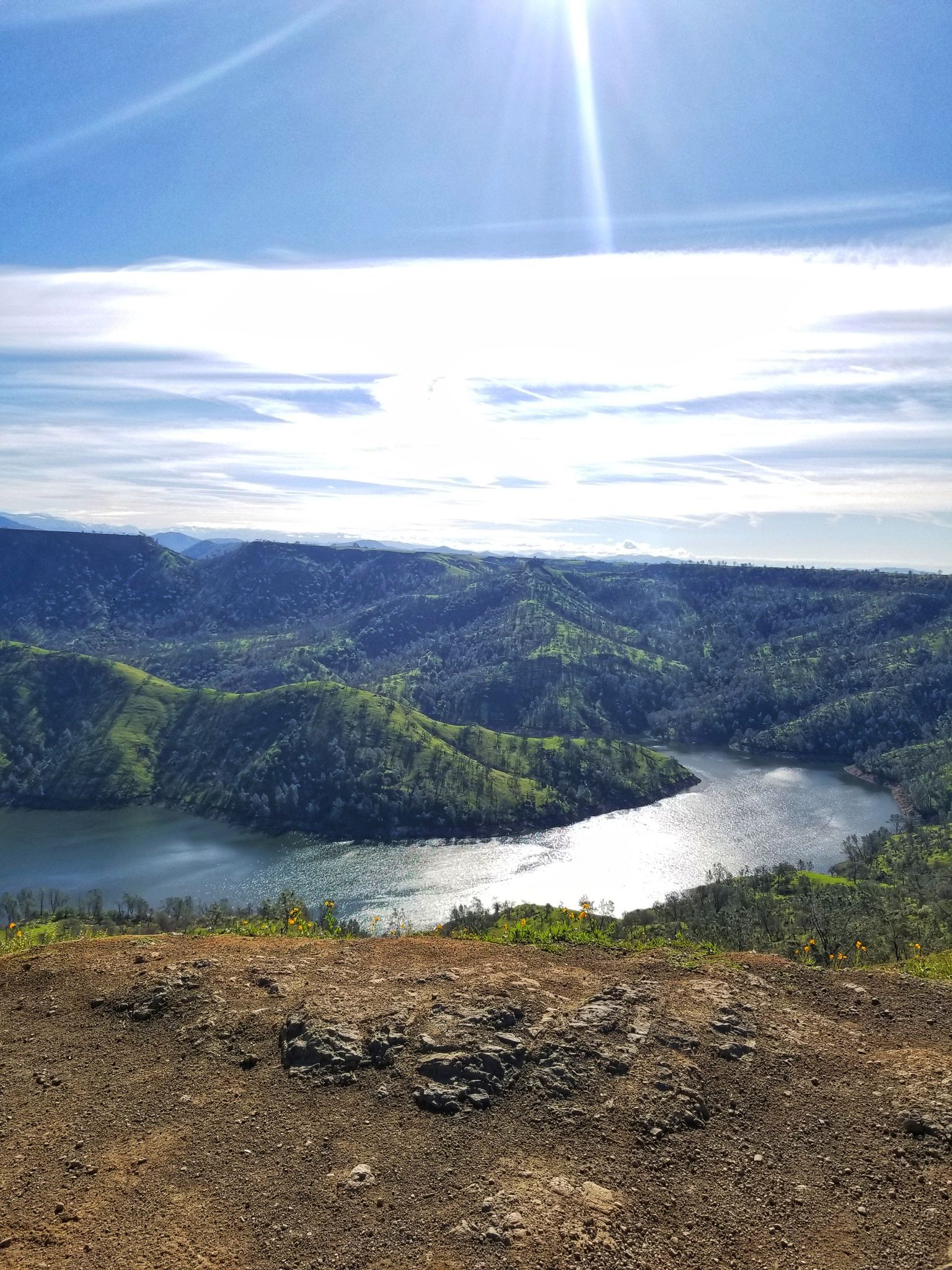 Panoramic view of a winding river through lush green hills under bright sun. - Pincushion Peak Trail