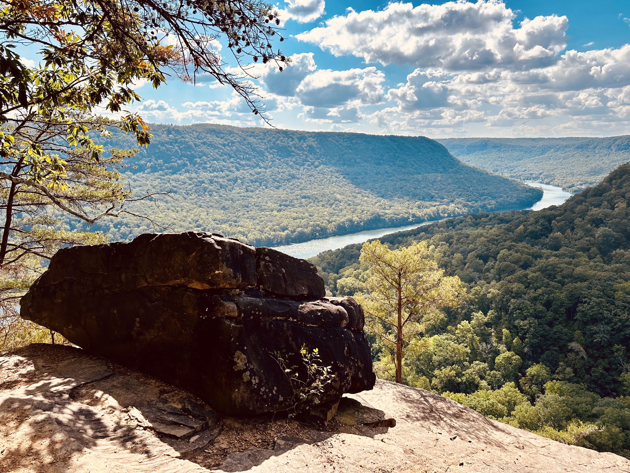 Large rock overlooking a forested river valley under a partly cloudy sky. - Rainbow Falls – Rainbow Lake Wilderness loop from Signal Mountain