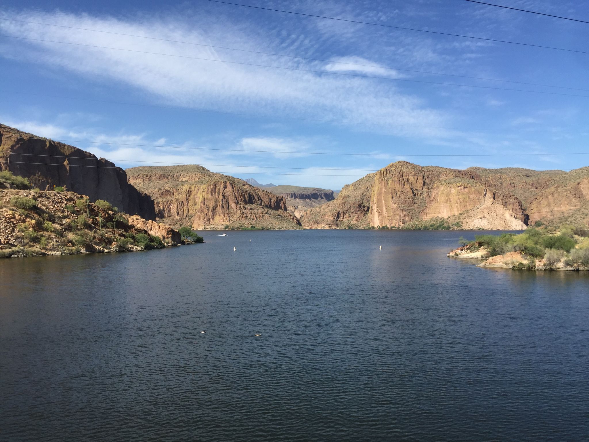 Wide lake framed by towering rocky cliffs under a clear blue sky. - Canyon Lake & Tortilla Flat via Apache Trail