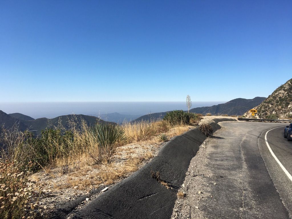 Mountain road overlooking a hazy valley and distant ocean under a clear sky. - Mount Lukens and Josephine Peak Loop