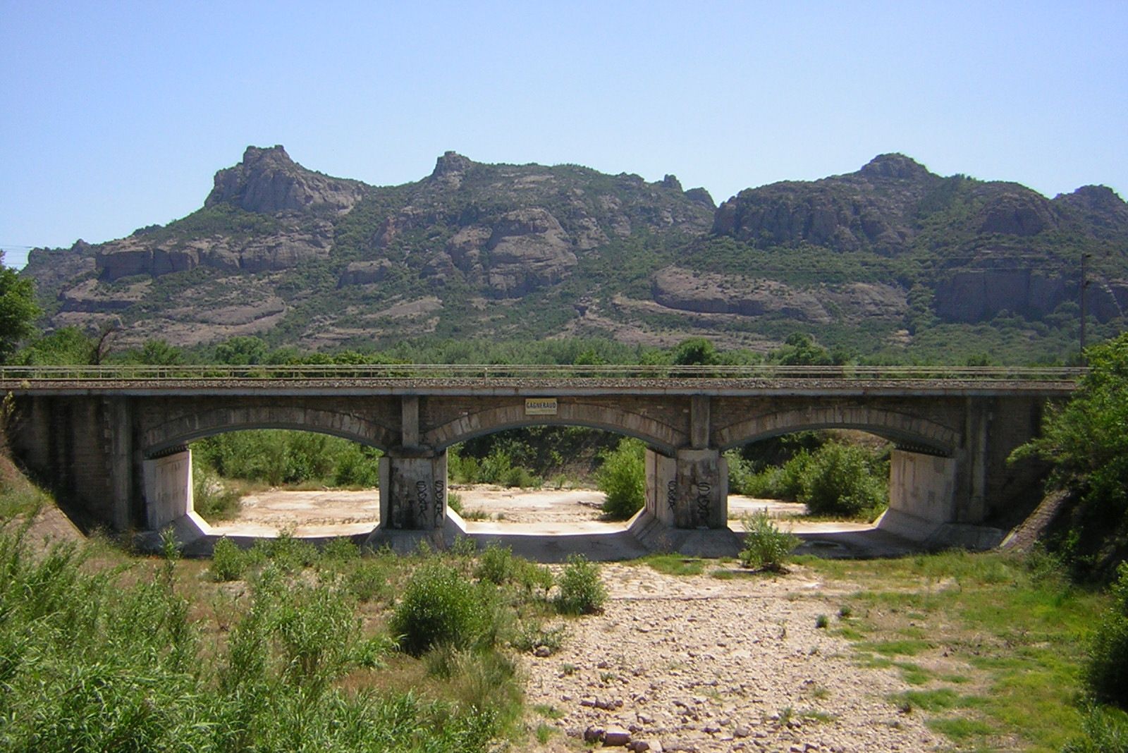 Brücke über den Fluss l'Endre, dahinter der Rocher de Roquebrune