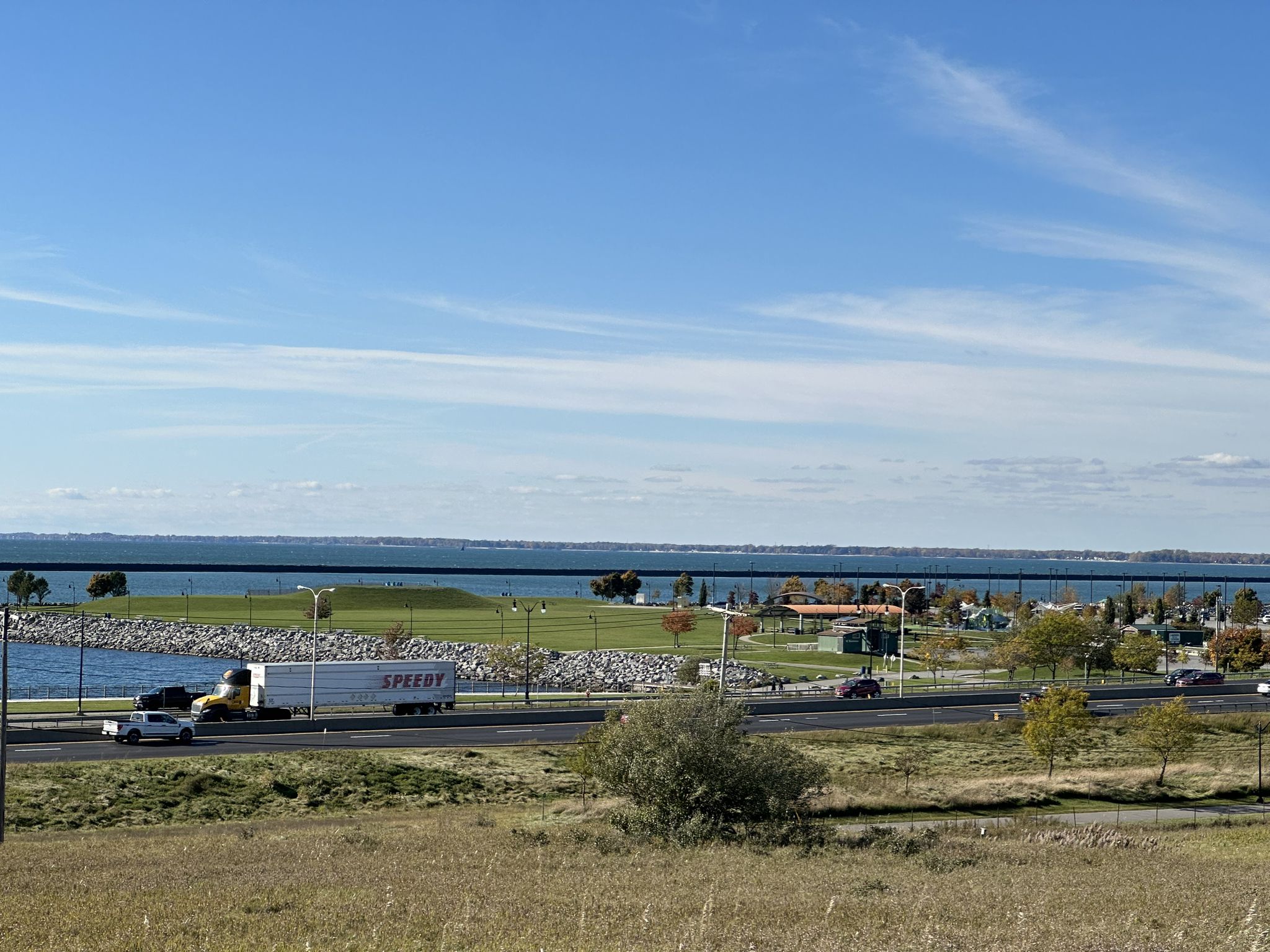 Wide water body, highway with traffic, and distant green land. - Tifft Nature Preserve loop