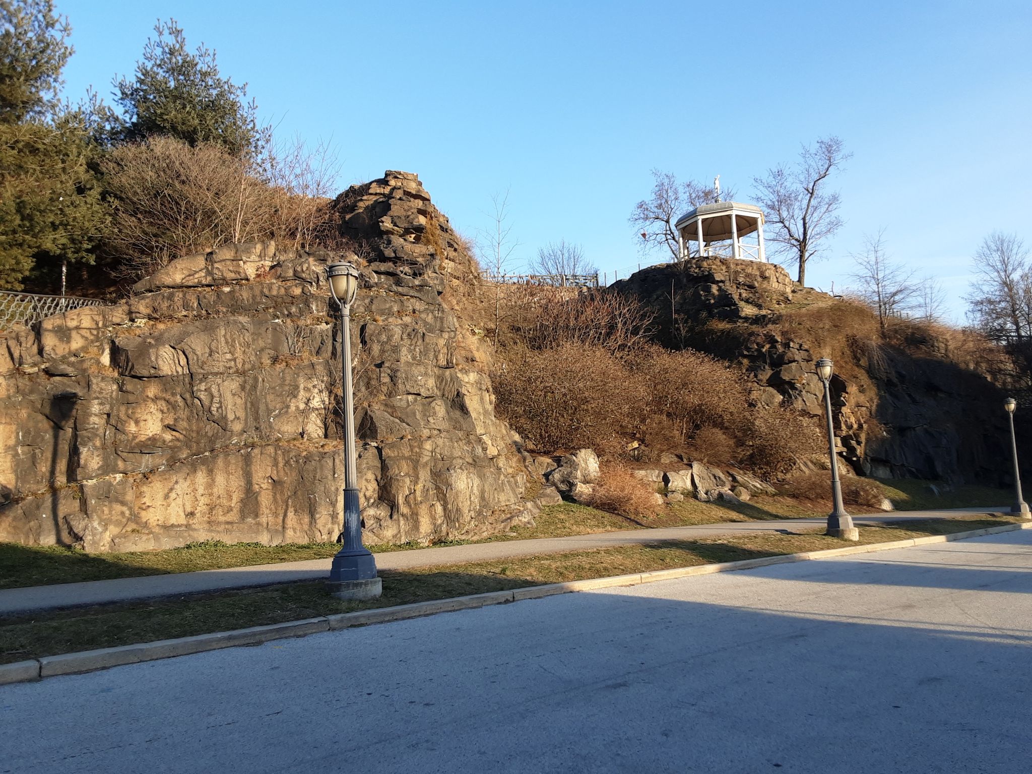 Rocky hillside with a white gazebo on top, path, and lampposts. - Boathouse Row – Turtle Rock Light loop from East Fairmount Park