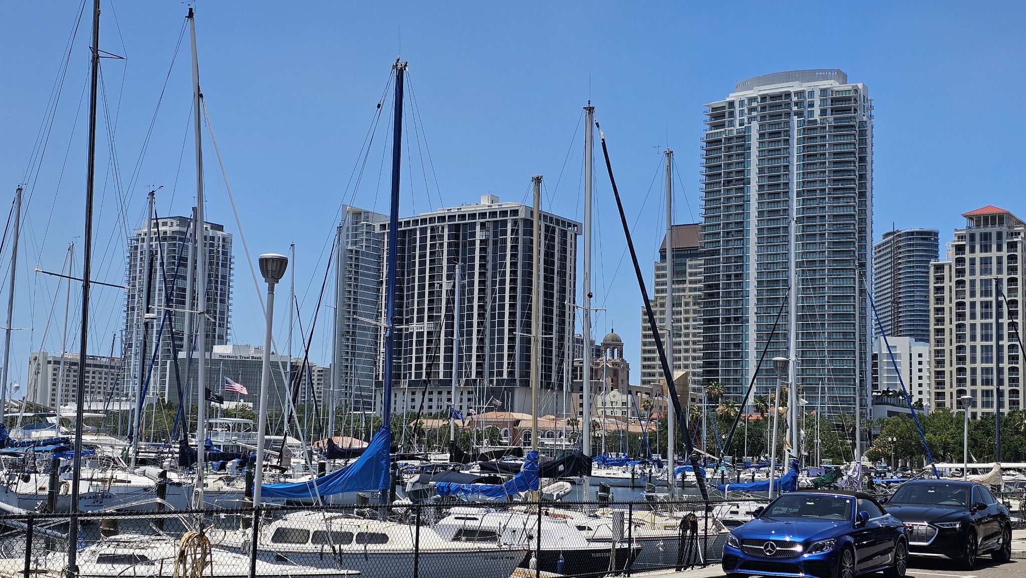 Sunny marina with sailboats and tall city buildings in the background. - St. Petersburg Pier Marina – St. Pete Pier loop from Saint Petersburg