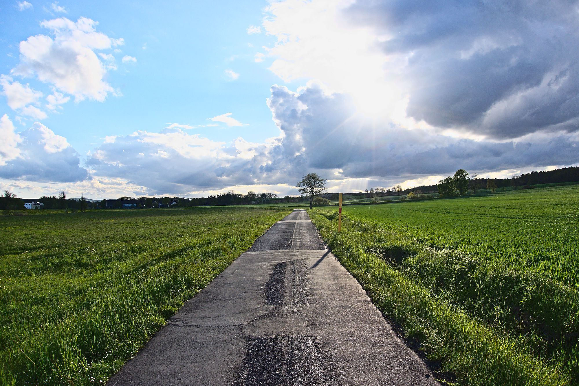 Zufahrt auf Burgebrach mit dicken Wolken im Rücken