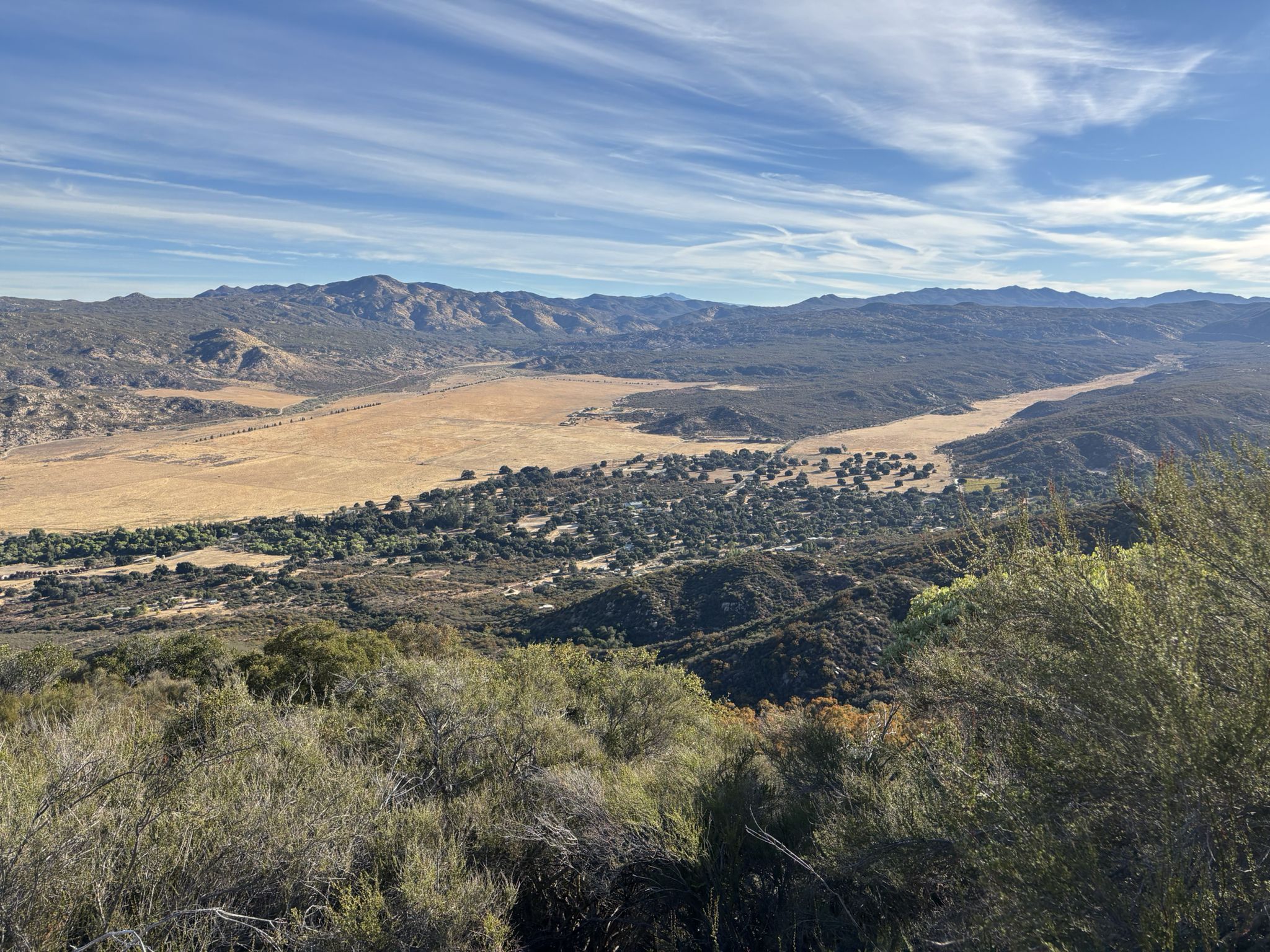 Vast dry valley with green trees, surrounded by distant mountains under a bright sky. - From Oak Grove to High Point – Palomar Mountain State Park