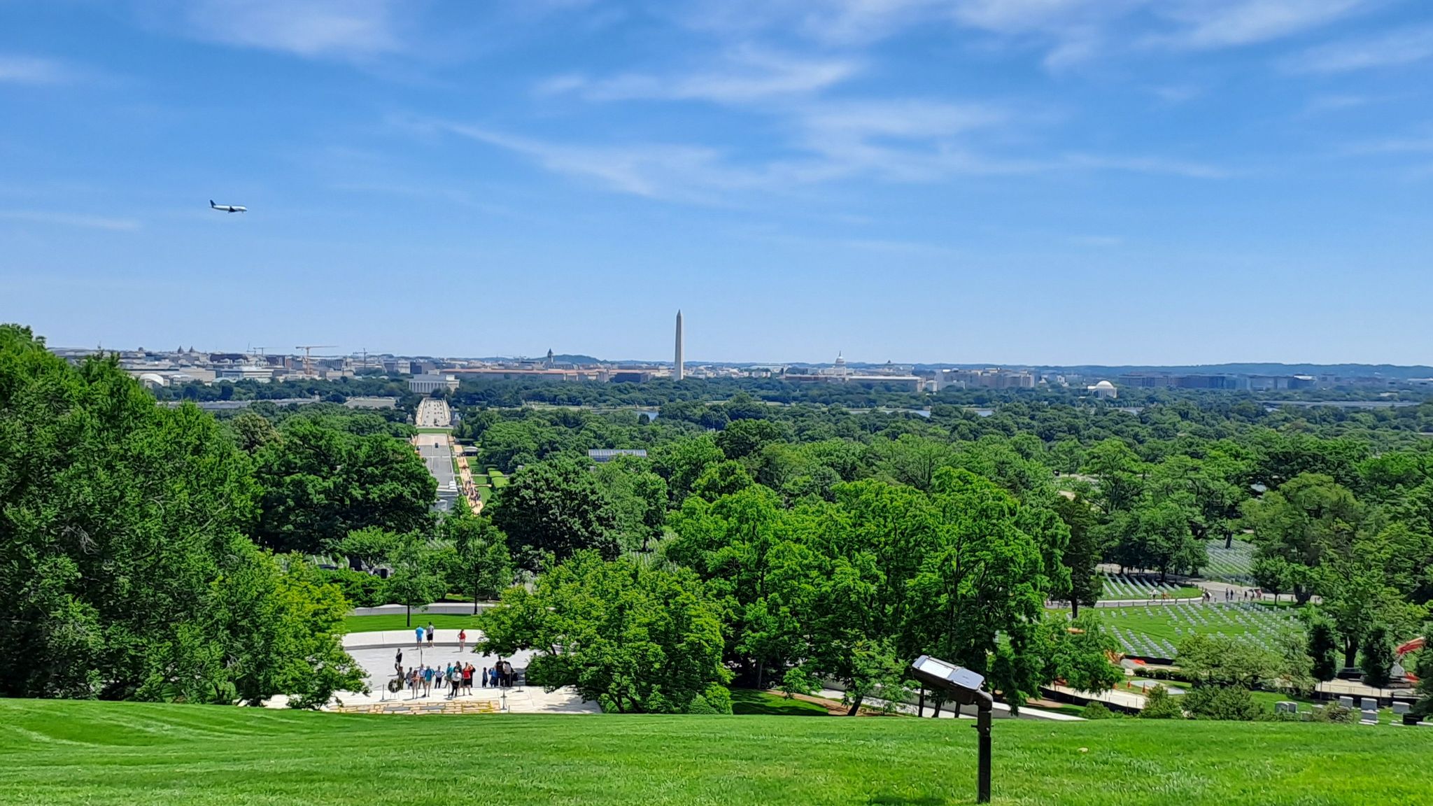 Panoramic view of a distant city skyline from a green, sunny hillside. - Arlington National Cemetery