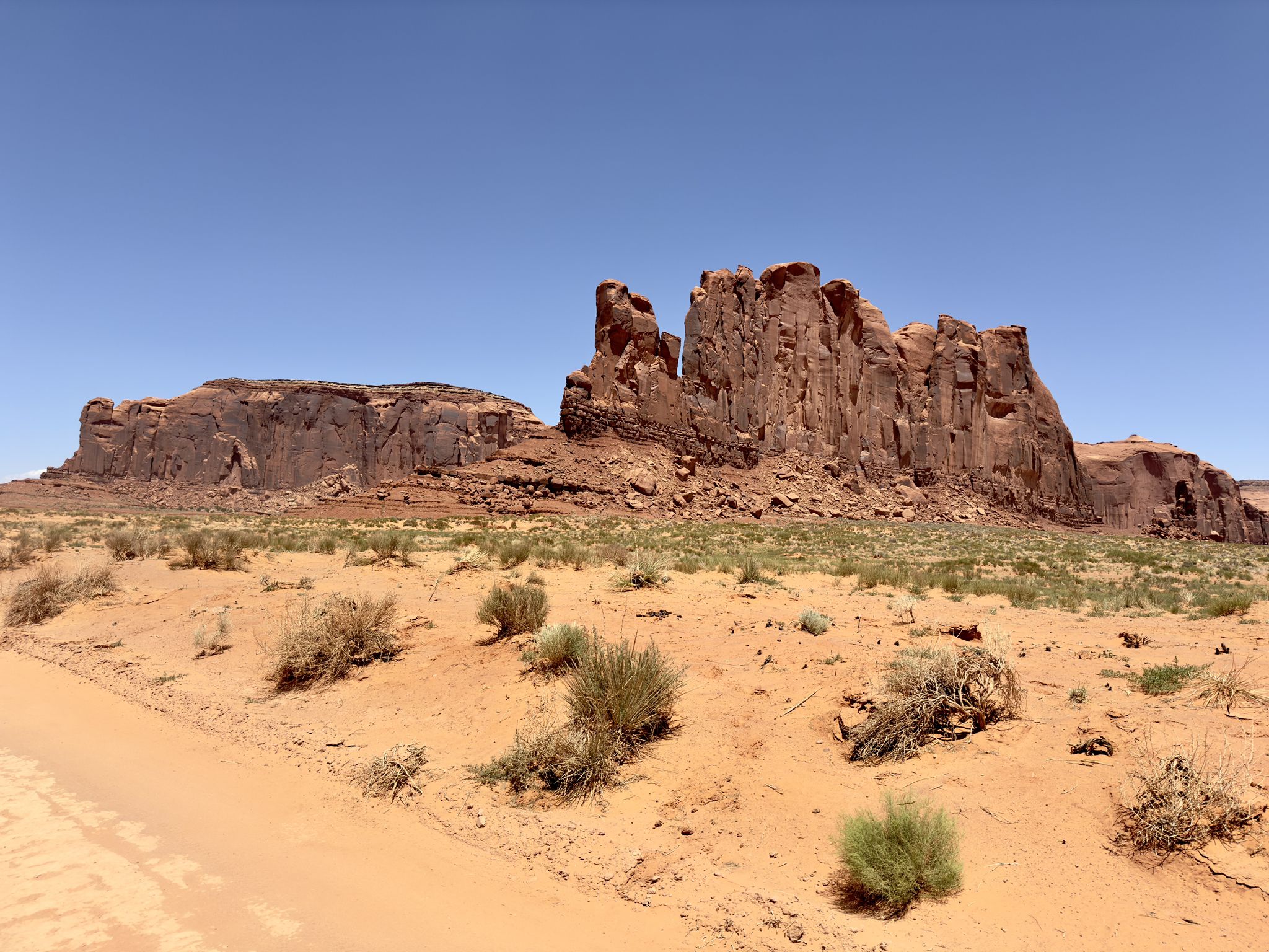 Vast desert landscape with large red rock formations under a clear blue sky. - Camel Butte and Three Sisters loop