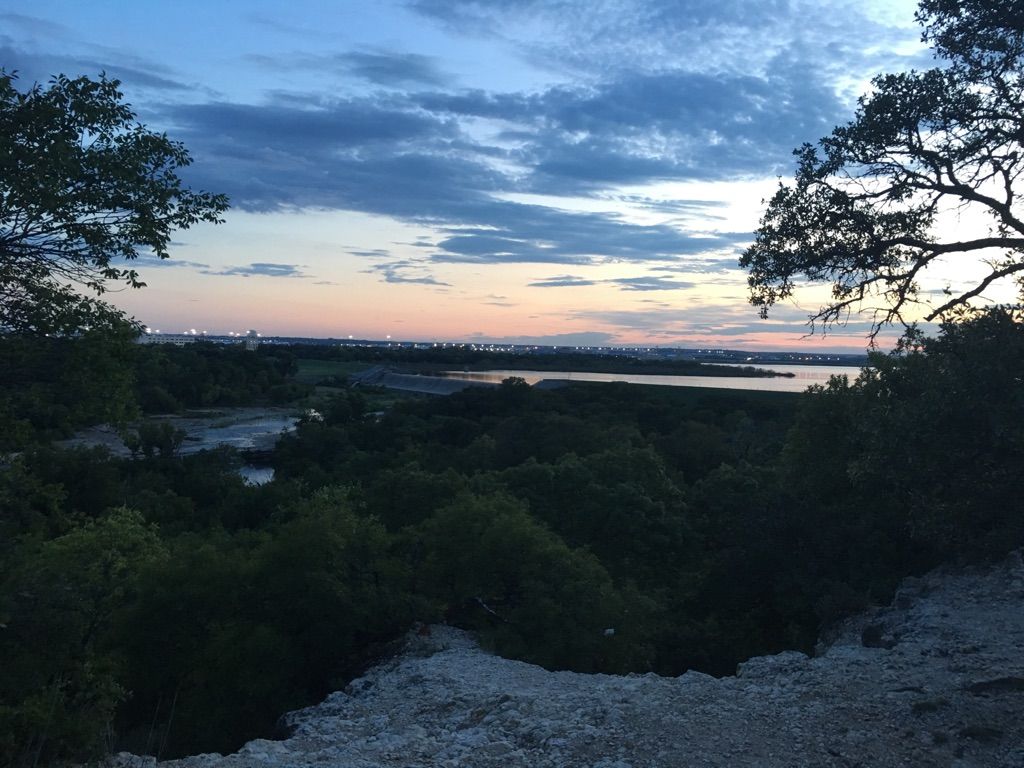 A wide river valley with dense trees at sunset, soft pink and blue sky. - The Dam Drop