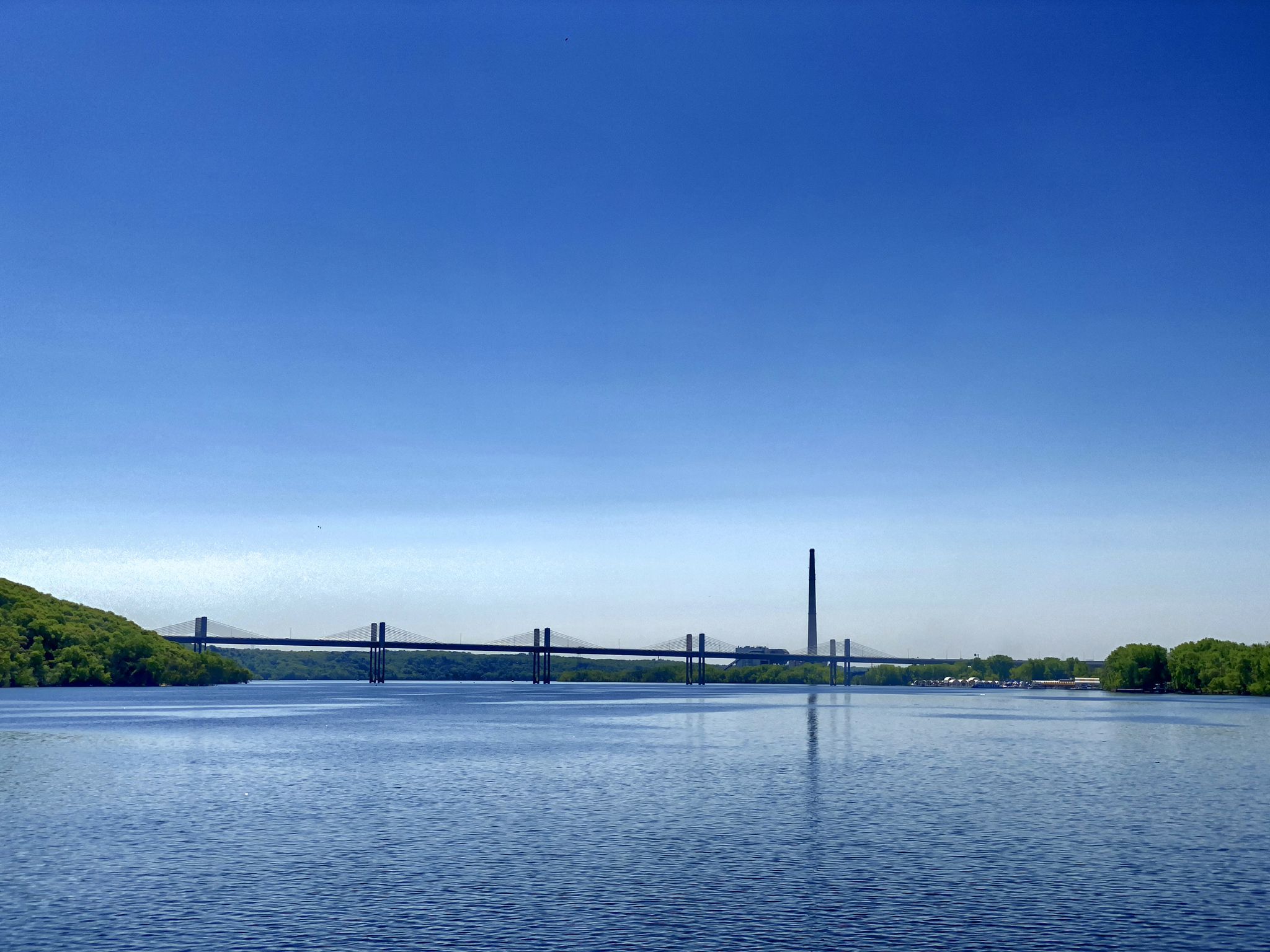 Distant bridge over wide blue water with a clear blue sky. - Gateway State Trail – Stillwater Lift Bridge loop from Stillwater