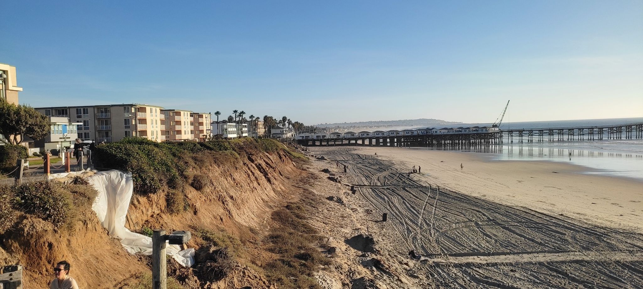 Sunny beach with a long pier, buildings, and people. - Ocean Front Walk – Mission Bay loop from Pacific Beach