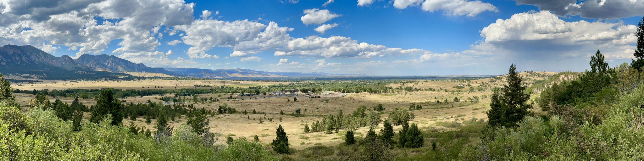 Panoramic view of a vast valley, mountains, and cloudy blue sky. - Marshall Mesa Loop