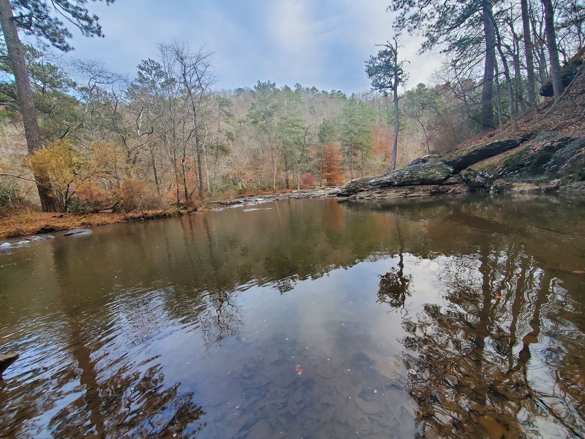 Calm river water reflects trees and sky, surrounded by autumn forest. - Christmas Fern – New Manchester Mill Ruins loop from Sweetwater Creek State Park
