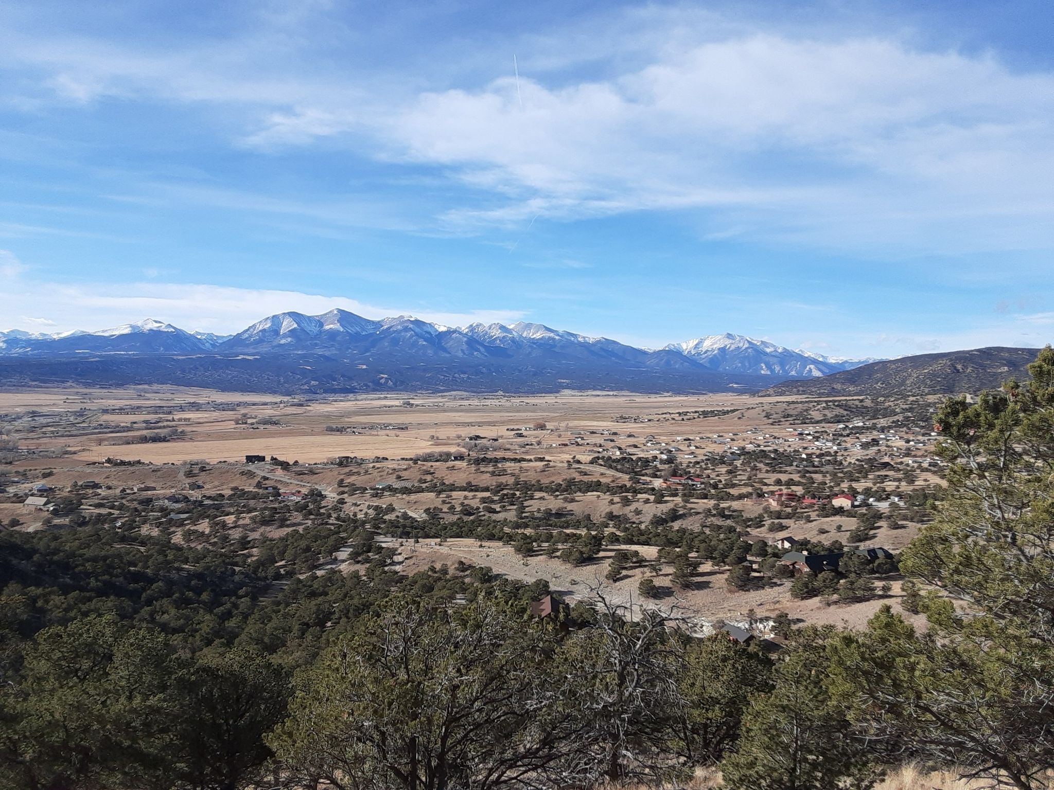 Wide valley with a town and distant snow-capped mountains under a bright sky. - Tenderfoot Hill Loop