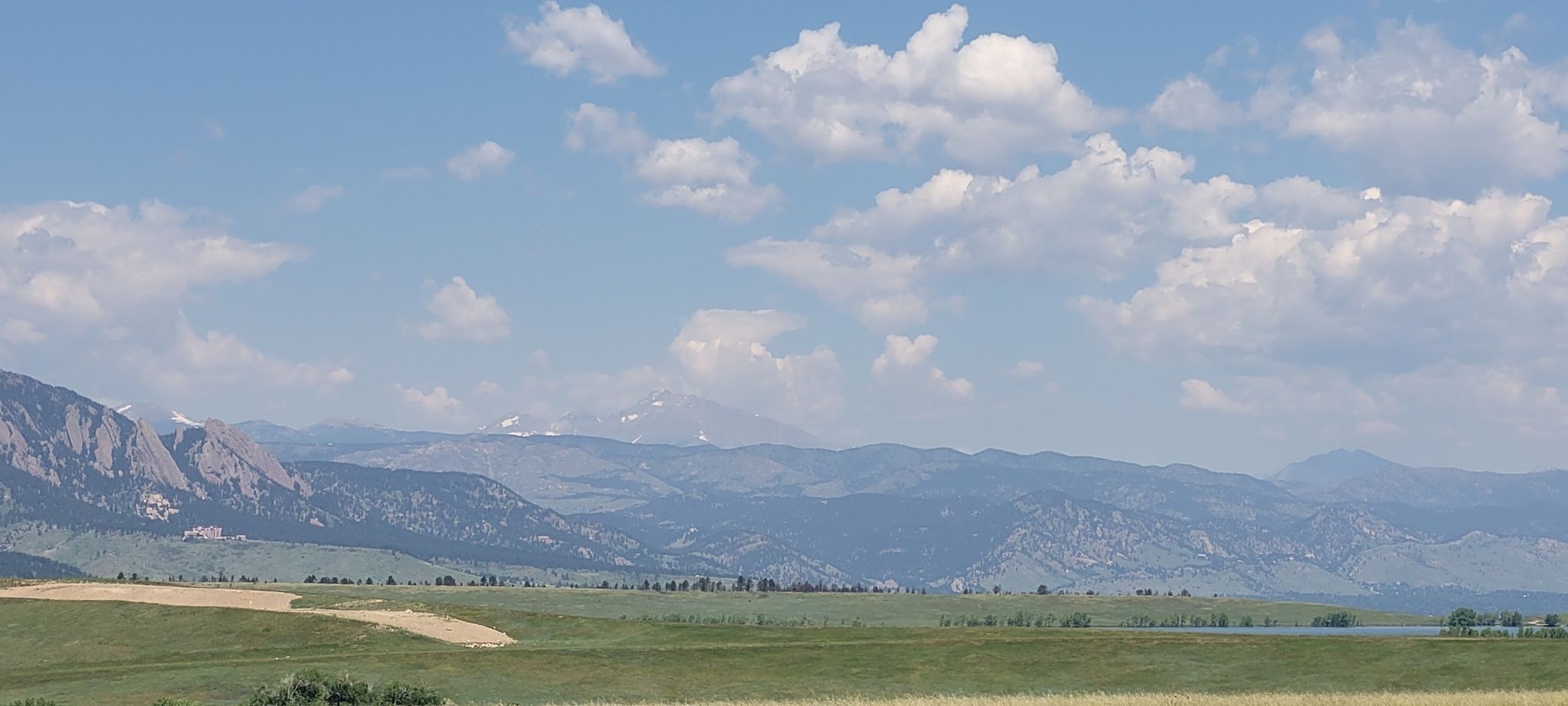 Wide view of green fields, distant mountains, and a lake. - Meadowlark Trail – Marshall Mesa view loop from Superior