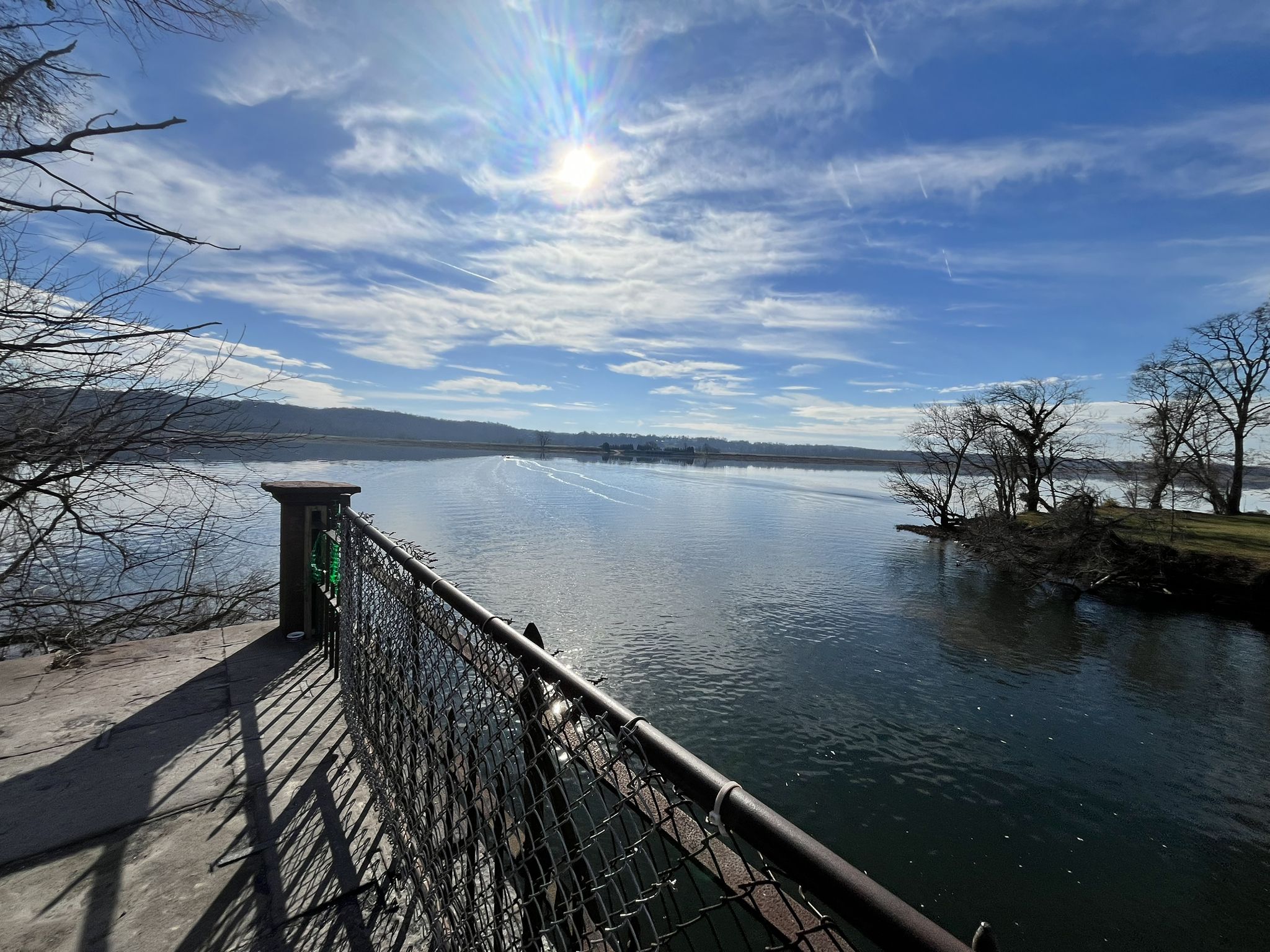 Wide river reflecting a bright sun, seen from a bridge with railing. - Riley’s lock – Historic White’s Ferry (Out of service) loop from Seneca