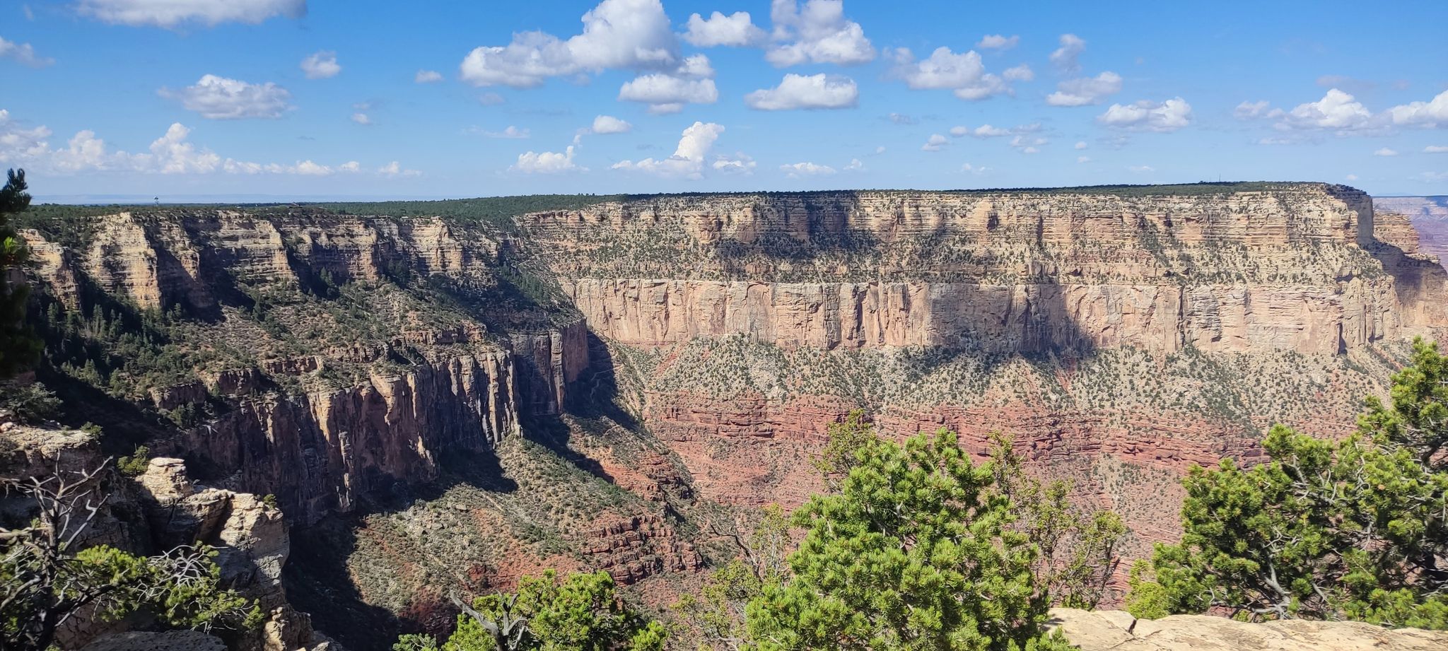 Wide canyon landscape with layered rock formations under a bright blue sky. - Bright Angel Trailhead – Hopi Point viewpoint loop from Grand Canyon