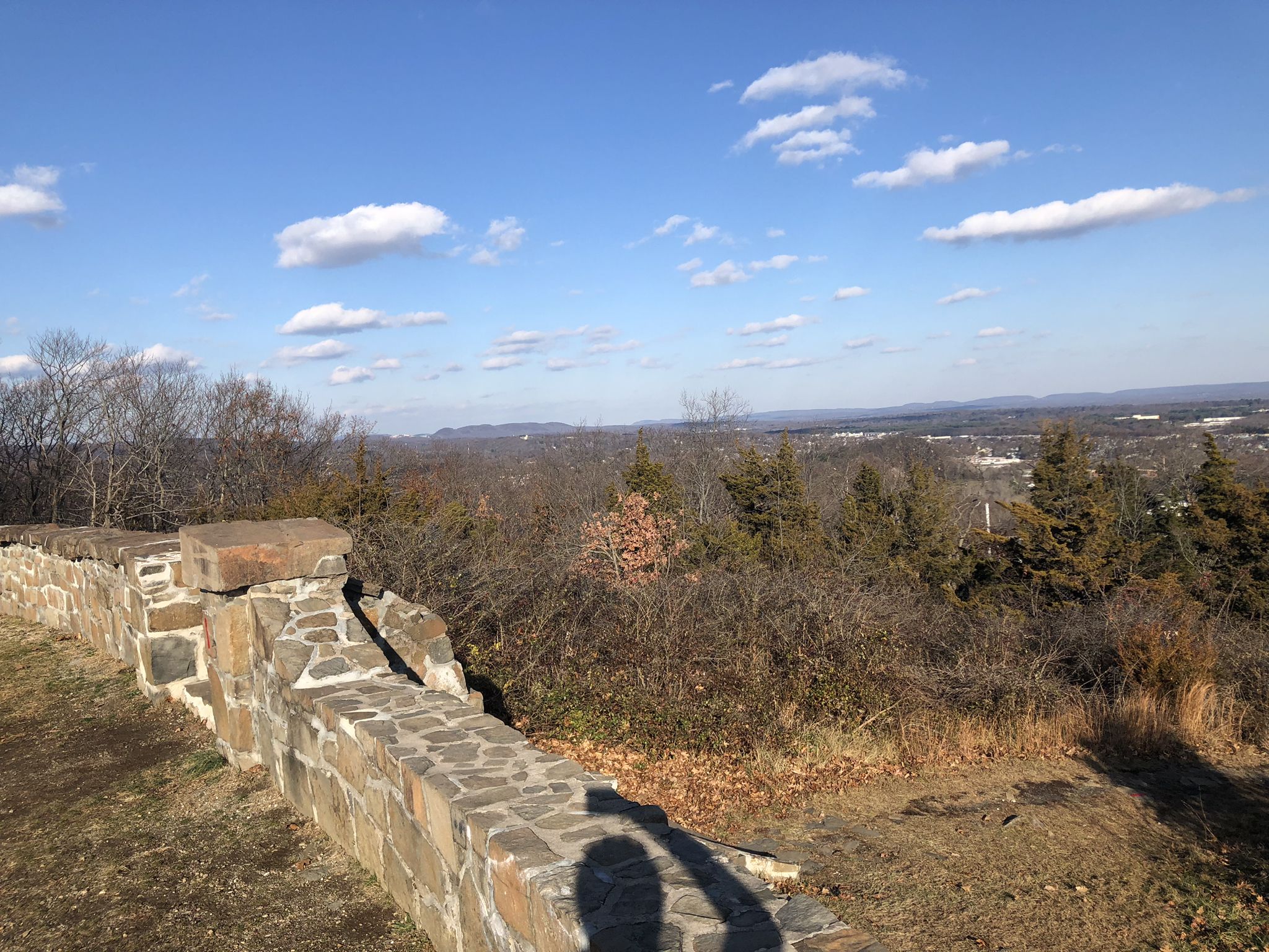 Stone wall in foreground, dry trees, distant landscape, and a person's shadow. - Regicides and Westville Feeder Loop