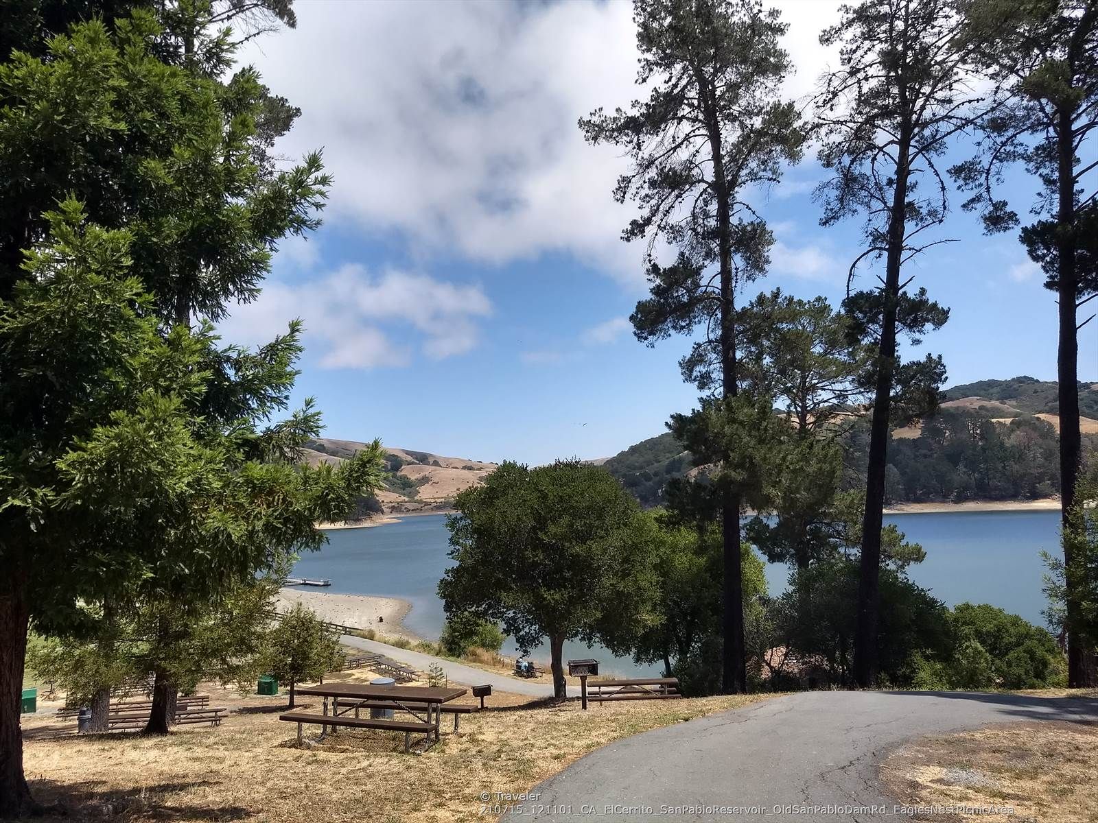 Picnic tables and a paved path framed by tall trees overlooking a lake. - Tilden Park Steam Train – San Pablo Creek Bridge loop from El Sobrante