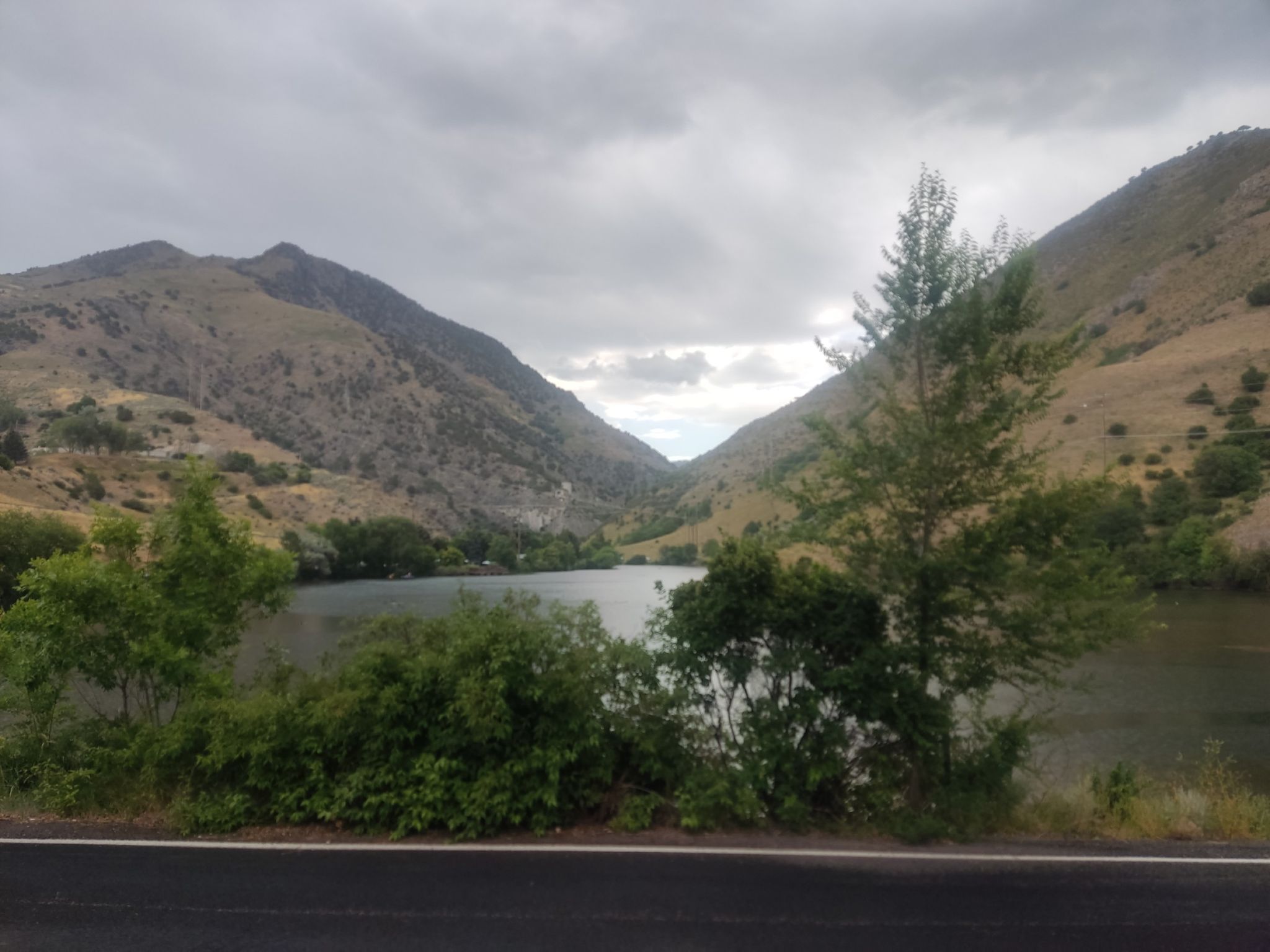 A lake in a mountain valley, with green trees and a cloudy sky. - First Dam loop from Logan