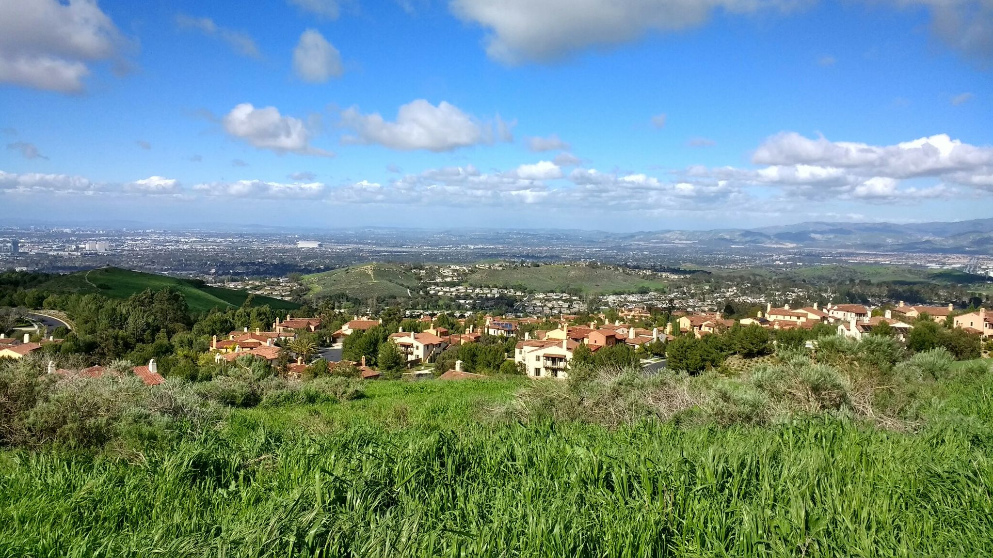 Panoramic view of a town nestled in green hills under a partly cloudy sky. - Shady Canyon, Turtle Ridge, & Community Trail loop